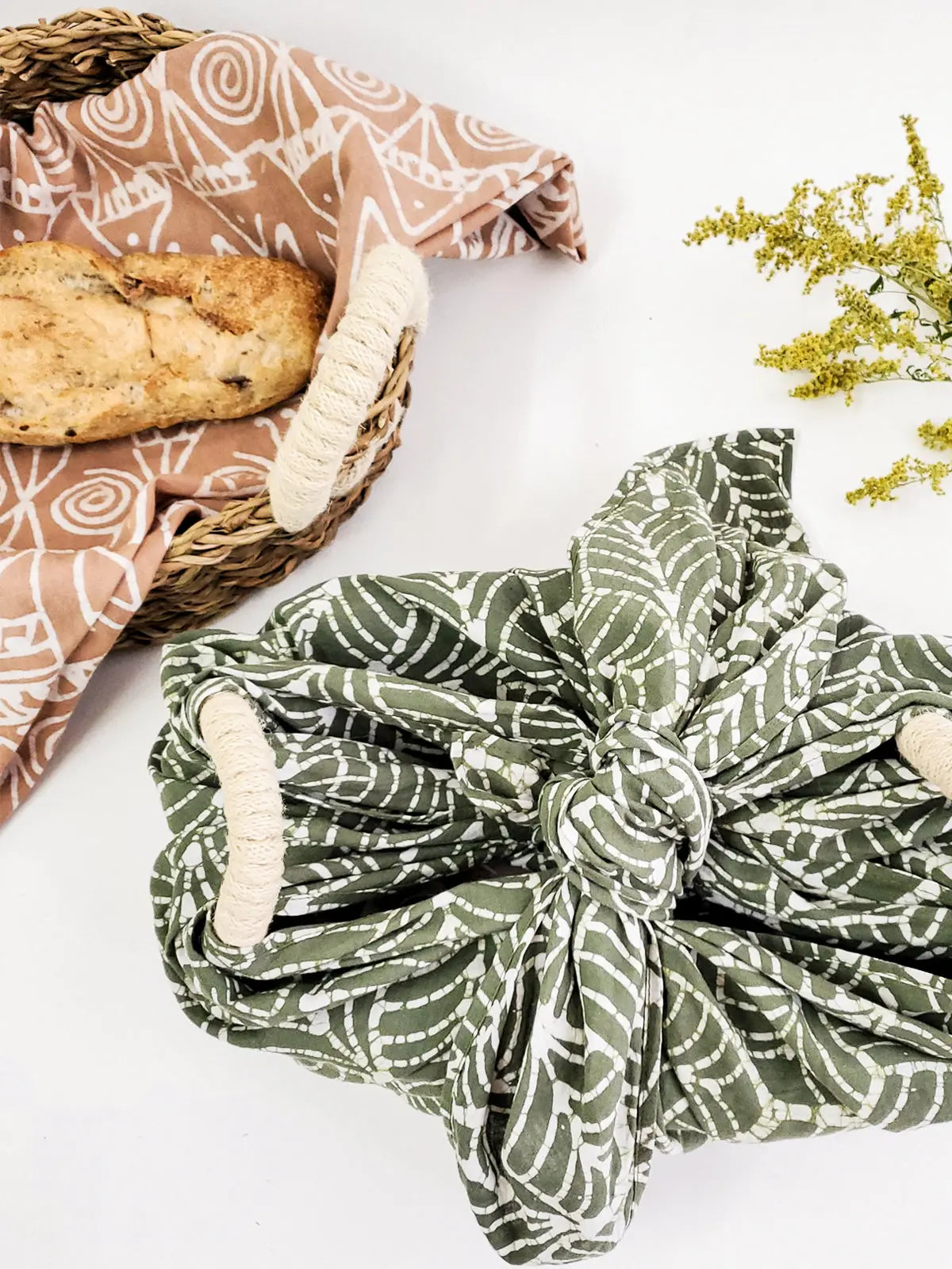Farmhouse-style bread basket with patterned cloth wrap, rustic woven basket, and fresh loaf for cozy kitchen decor