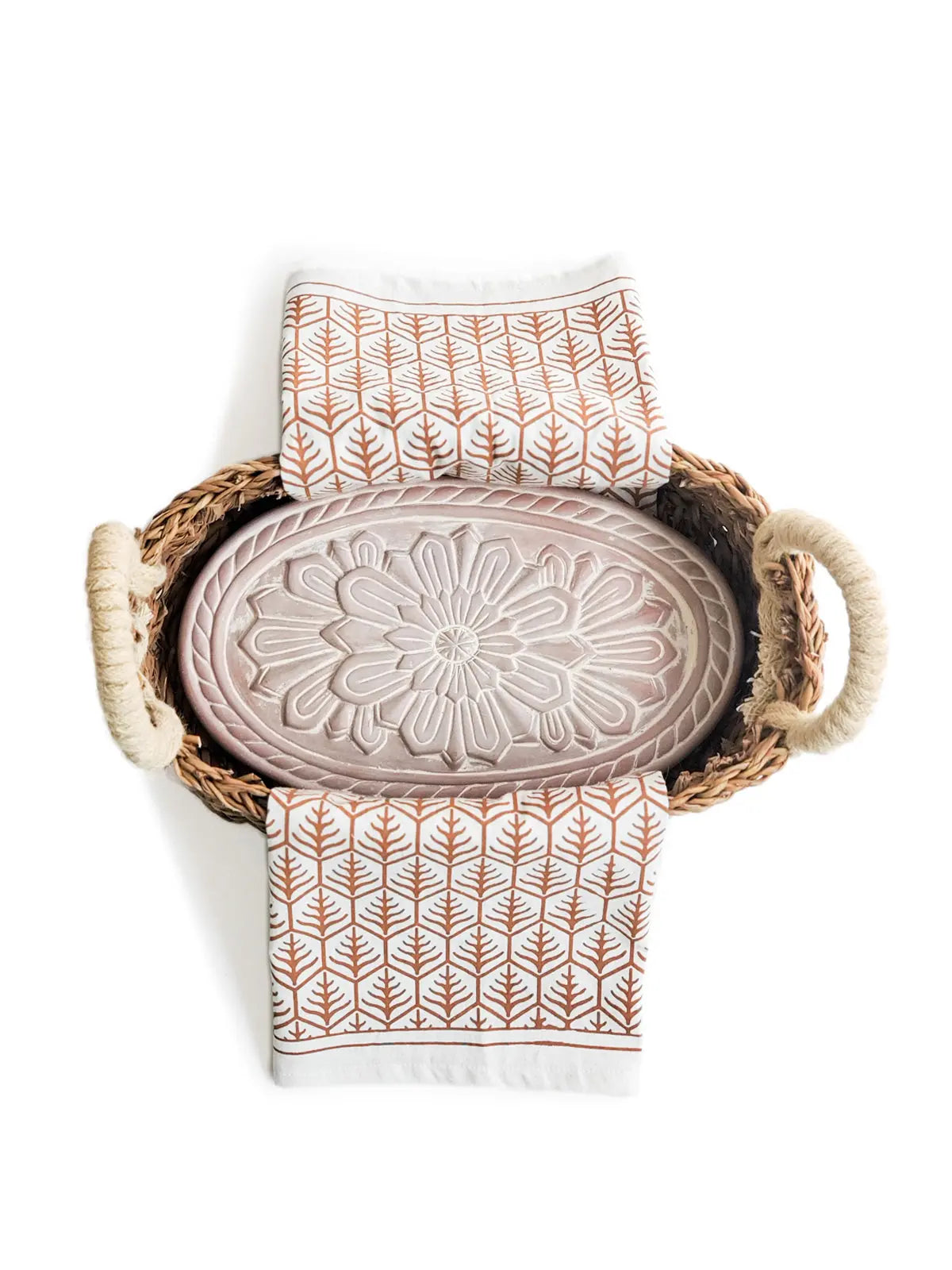 Woven basket with floral embossed tray and leaf-patterned kitchen towels, farmhouse decor