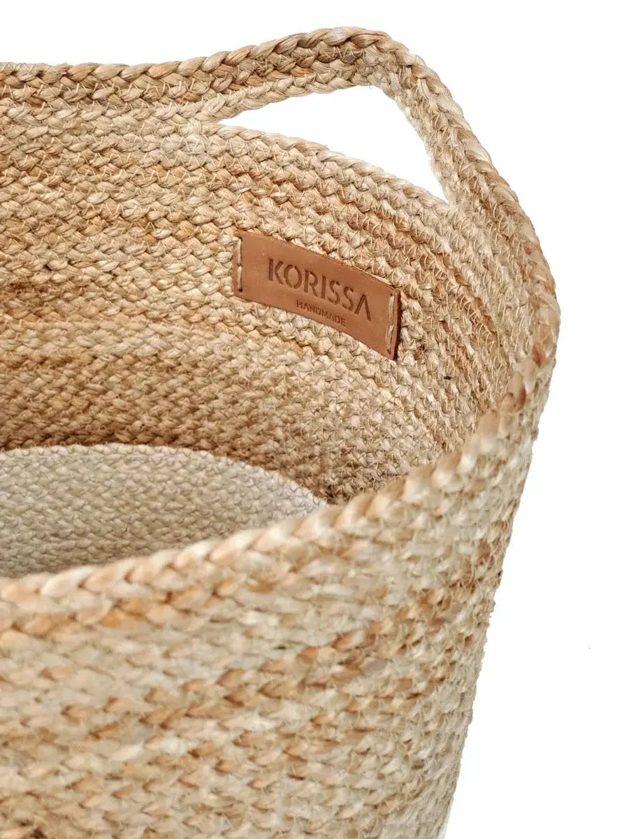 Farmhouse-style bread basket with artisan loaf, cheese, grapes, and rosemary on patterned linen