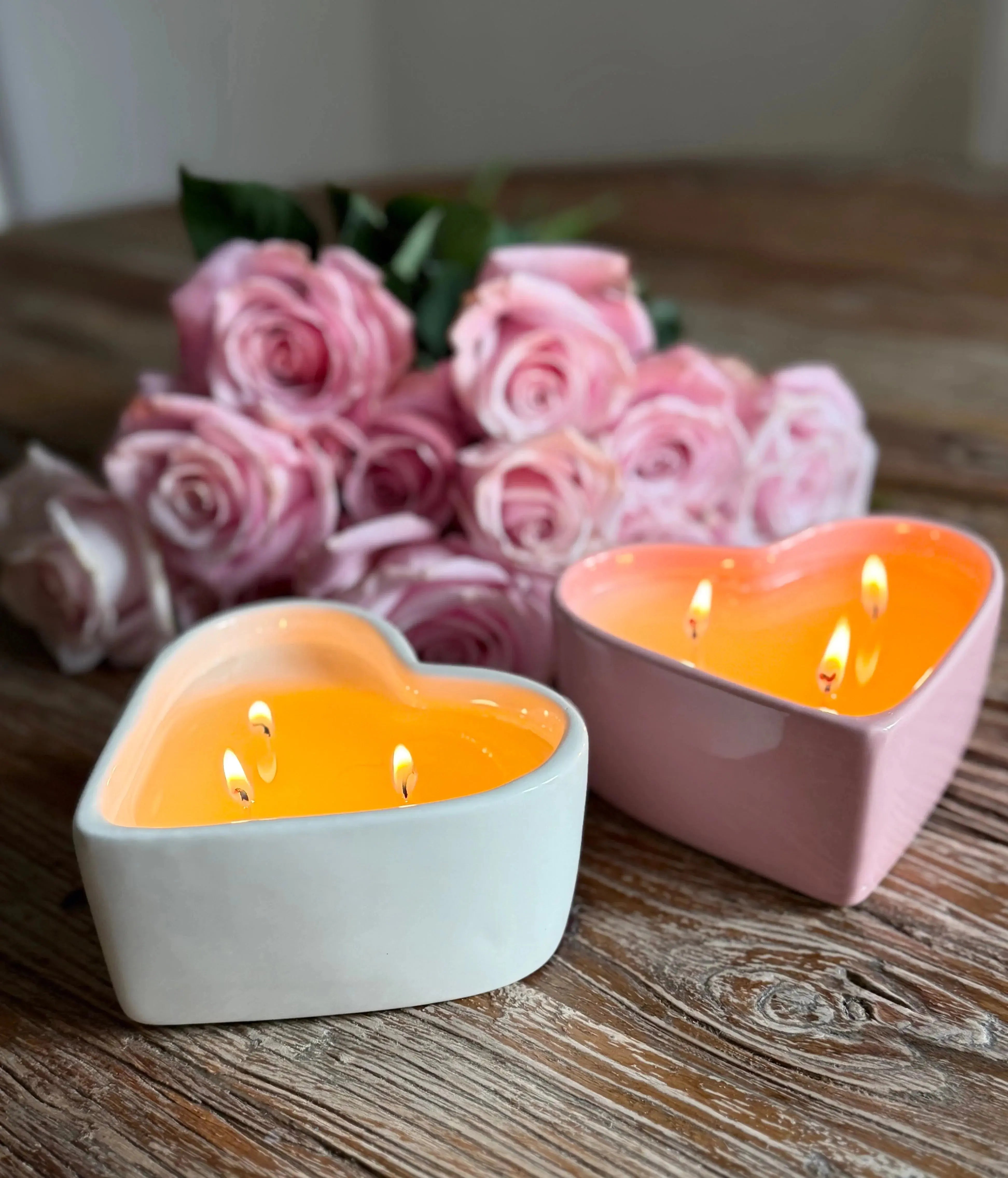 Heart-shaped candles with pink roses on rustic wood, cozy farmhouse decor