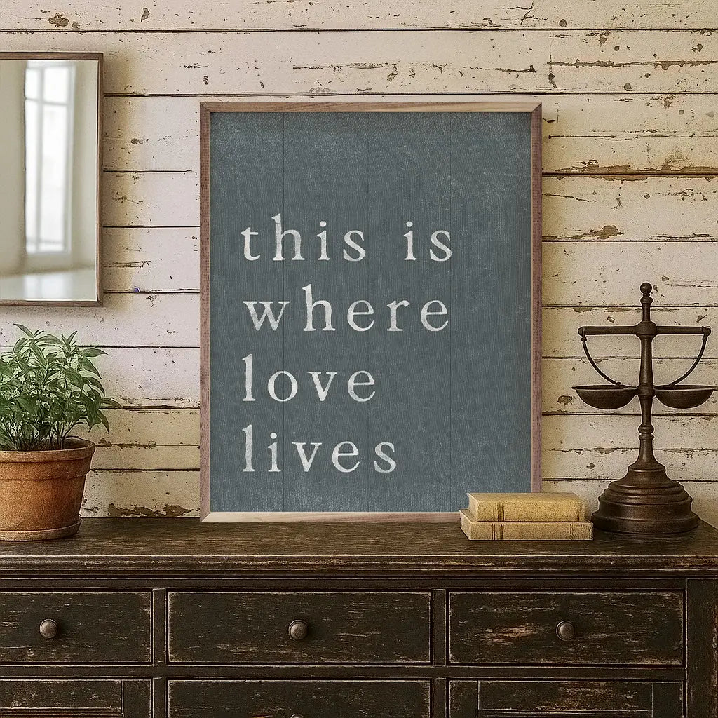 chalkboard with text "this is where love lives" on top of wooden chest against a wooden wall