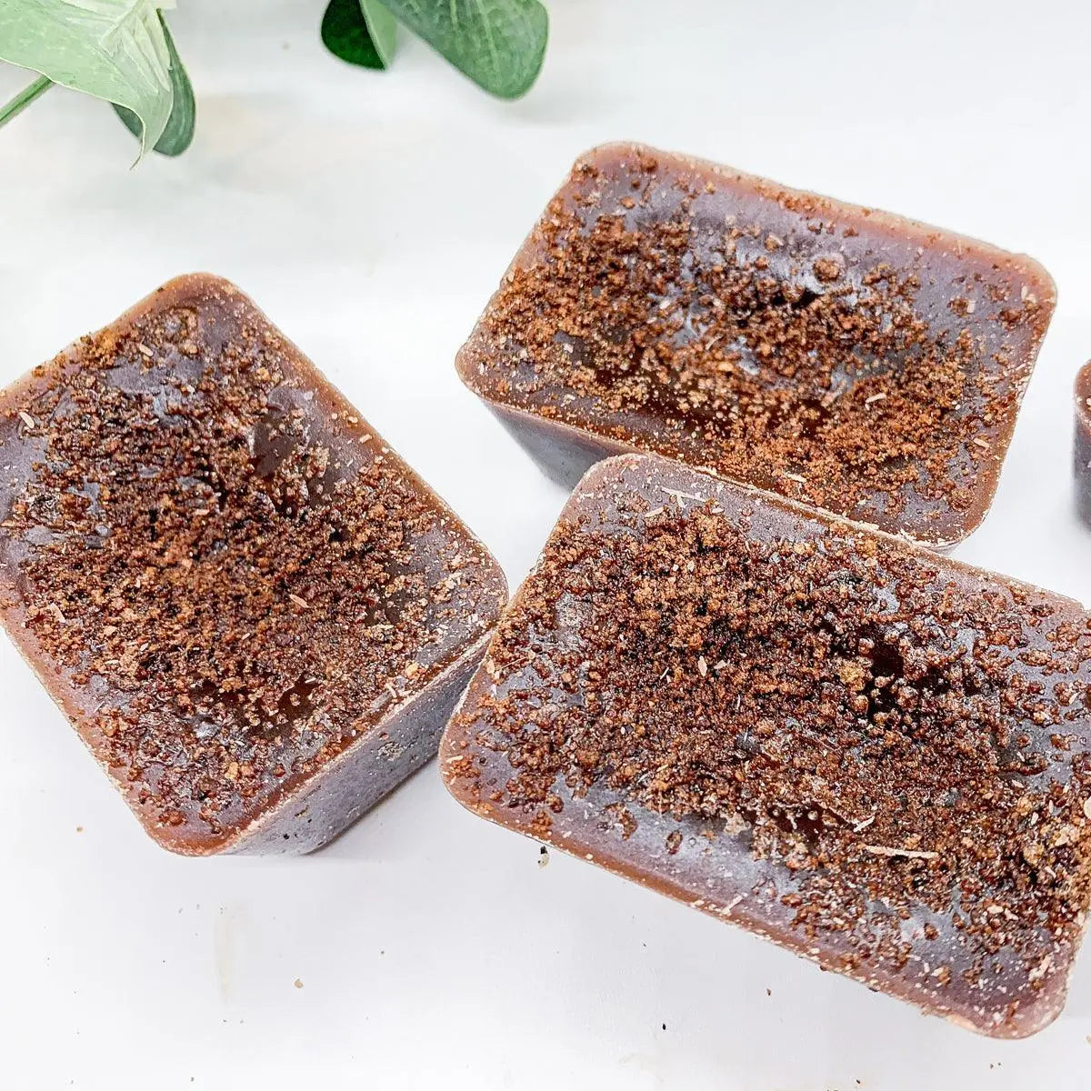 Three rectangular brown soap bars with a textured surface on a white background.