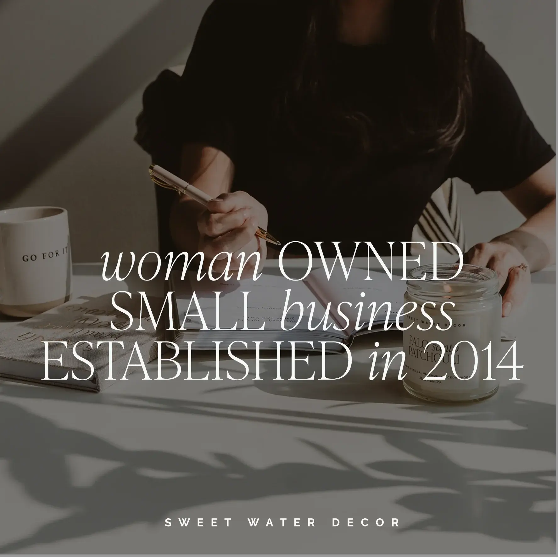 Woman writing at desk with cozy candle and mug, small business home decor