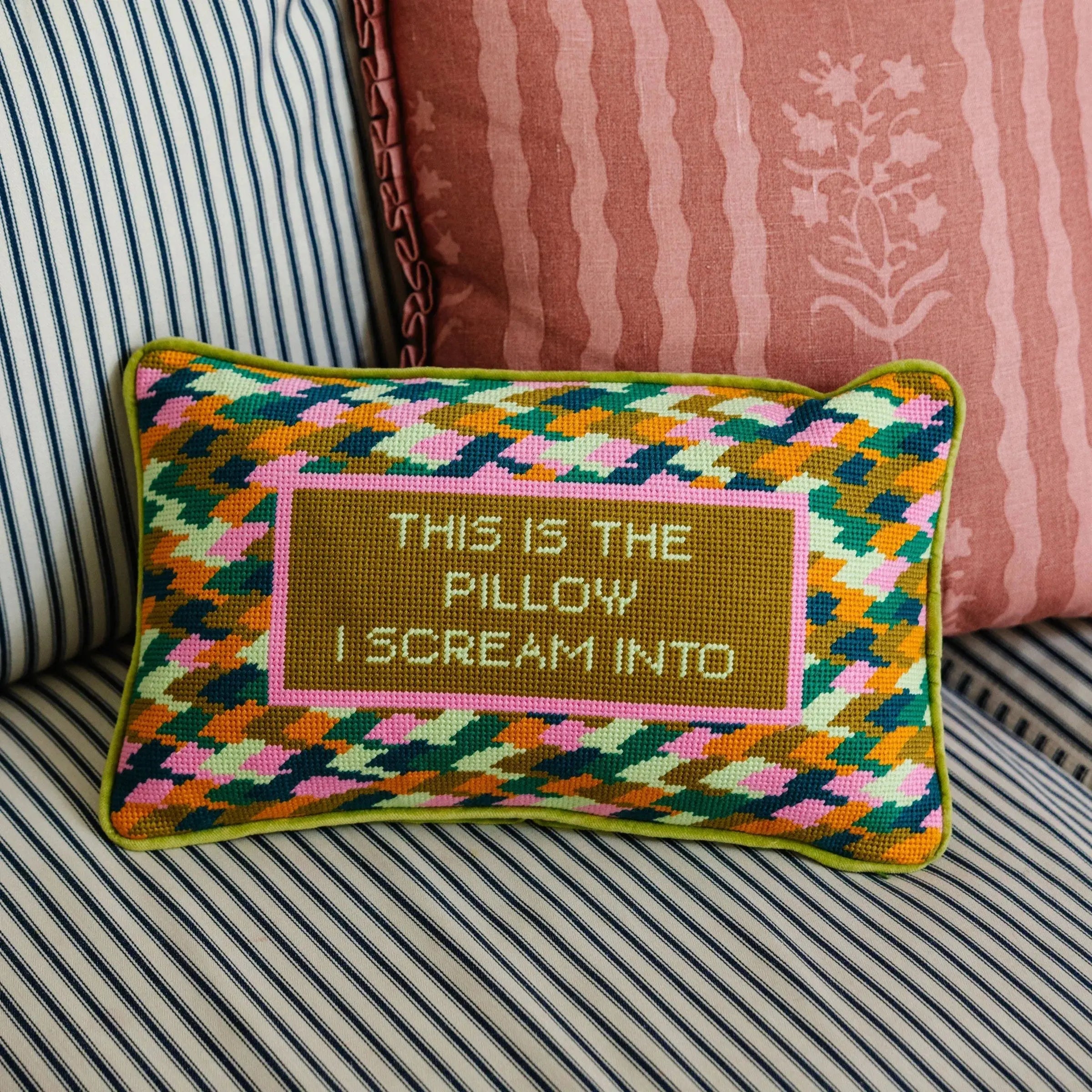 Colorful pillow with text on a striped couch