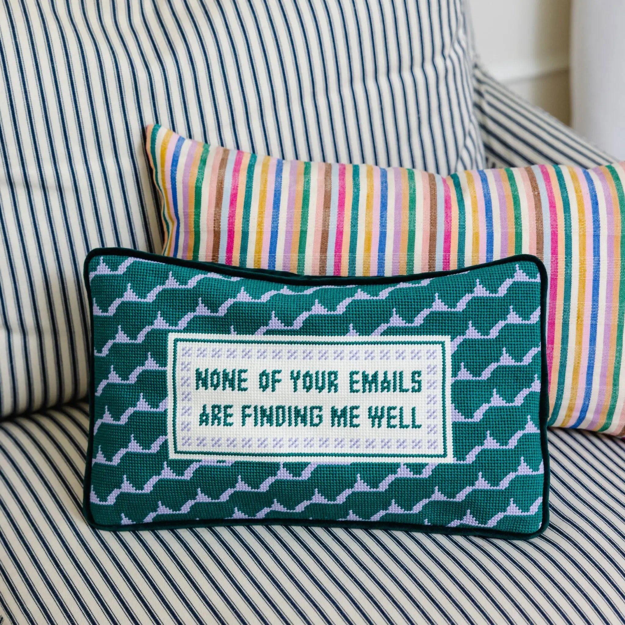 Decorative pillow with text on a striped sofa
