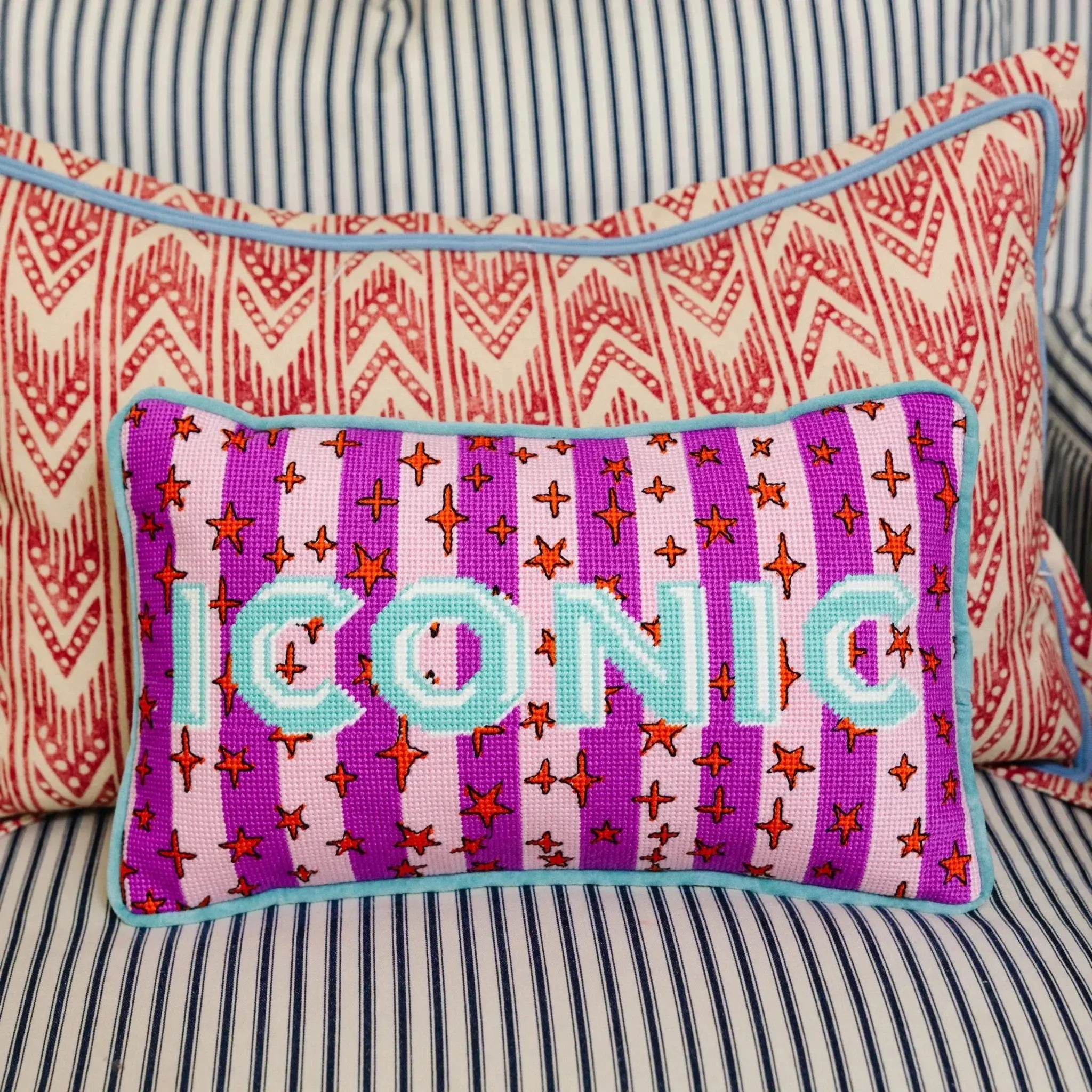 Decorative pillow with 'ICONIC' text on a striped sofa