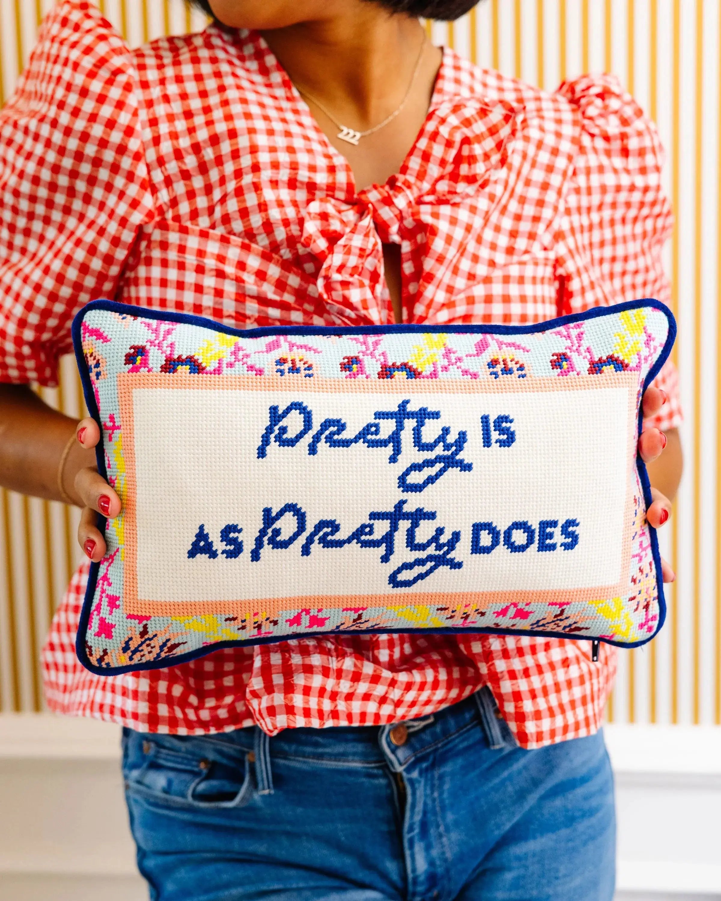 woman in a checkered shirt holding the Decorative pillow with text "Pretty is as Pretty Does"