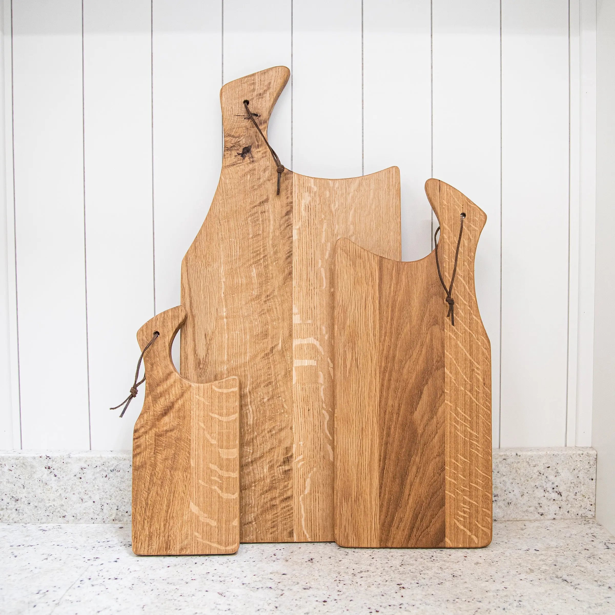Set of wooden cutting boards on a white wooden background
