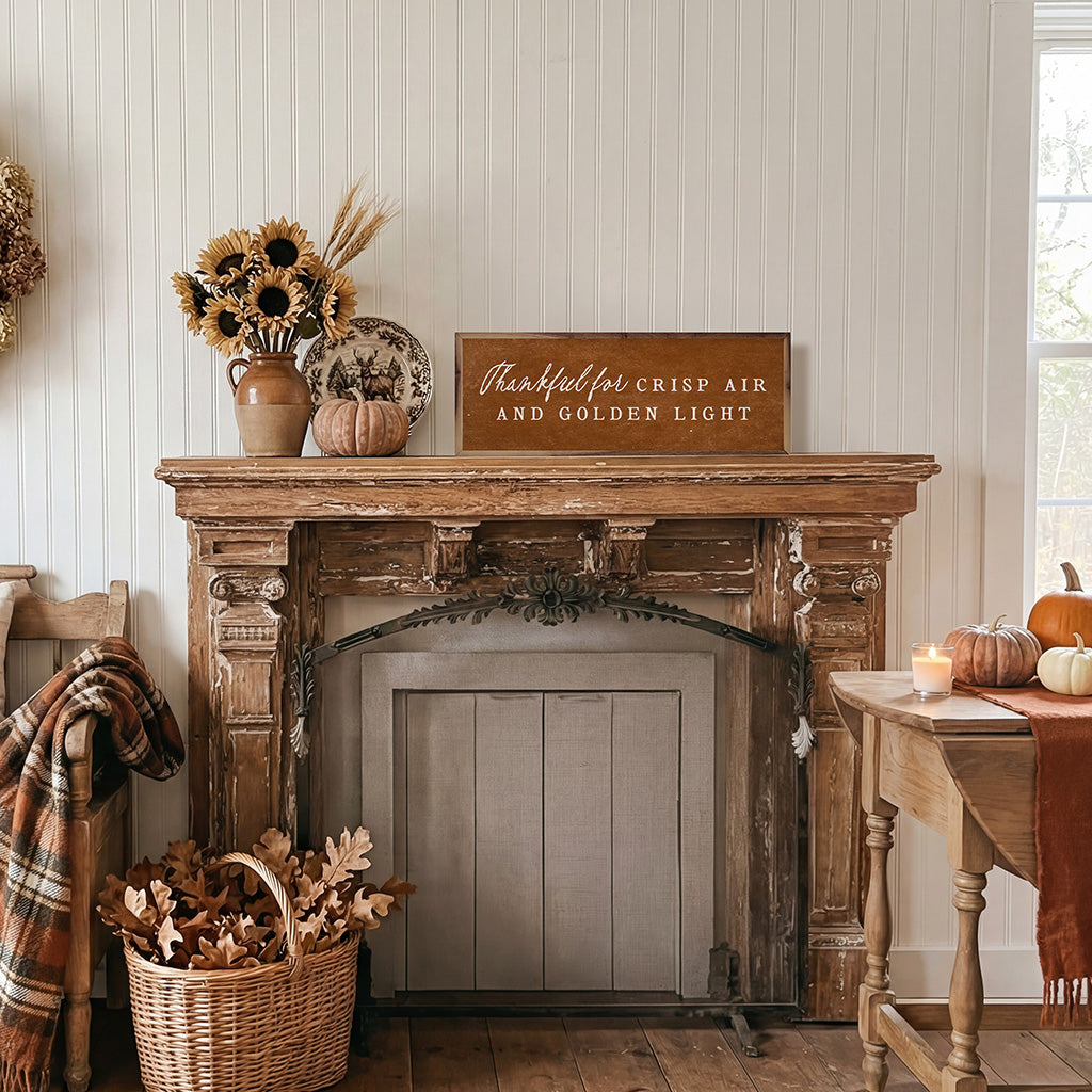 Decorative fireplace mantel with autumn-themed decor including pumpkins, sunflowers, and a sign.