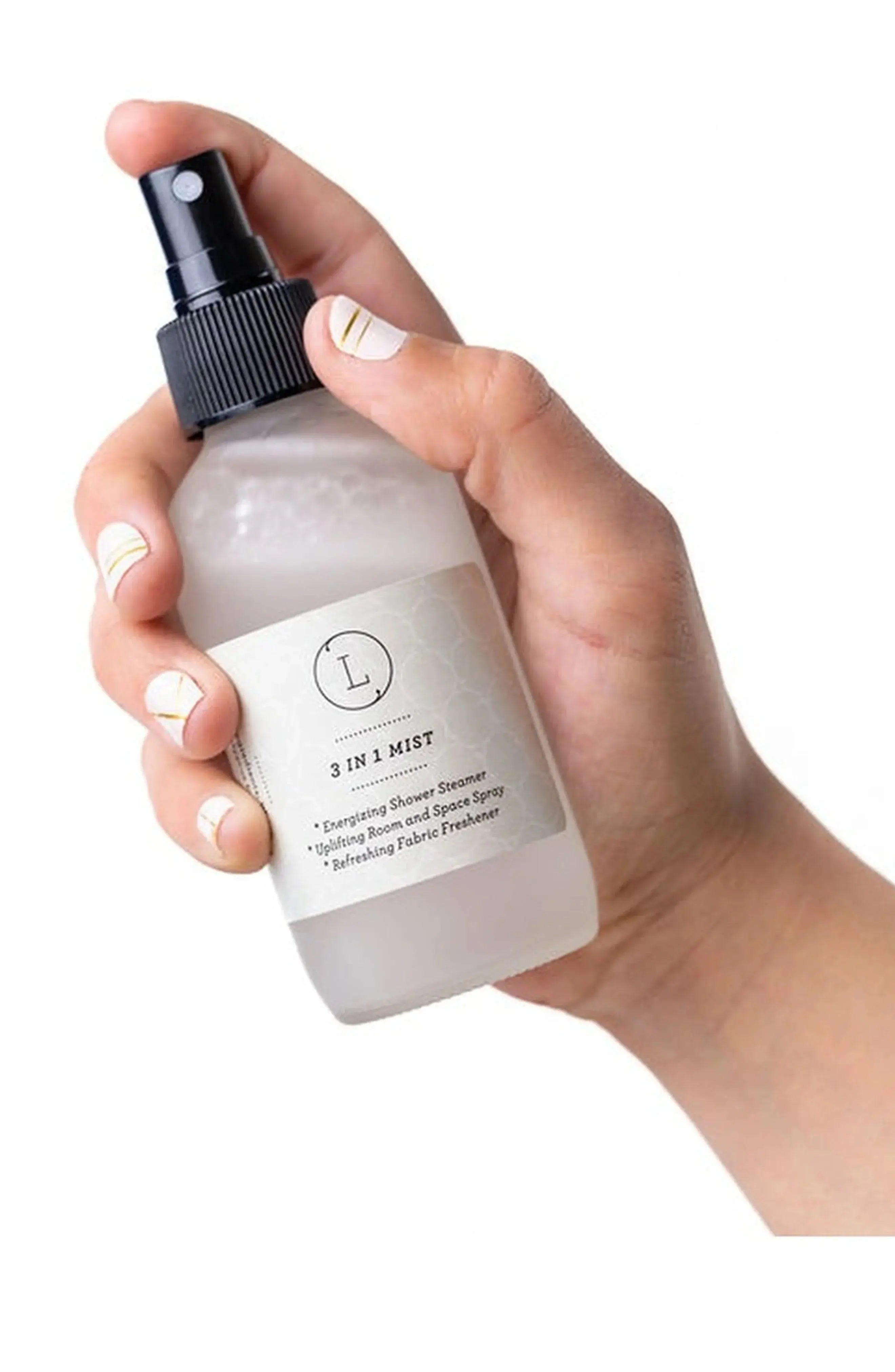 Hand holding 3-in-1 mist spray for shower, room & fabric freshener, cozy home essentials