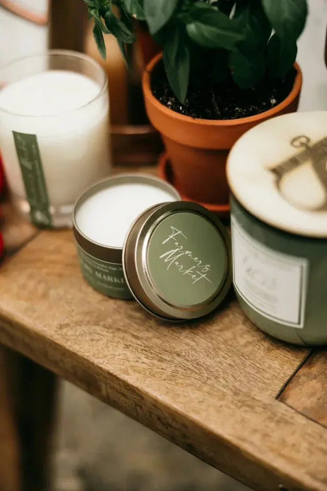 Farmers Market scented candle in rustic tin, cozy farmhouse decor with potted basil on wooden shelf