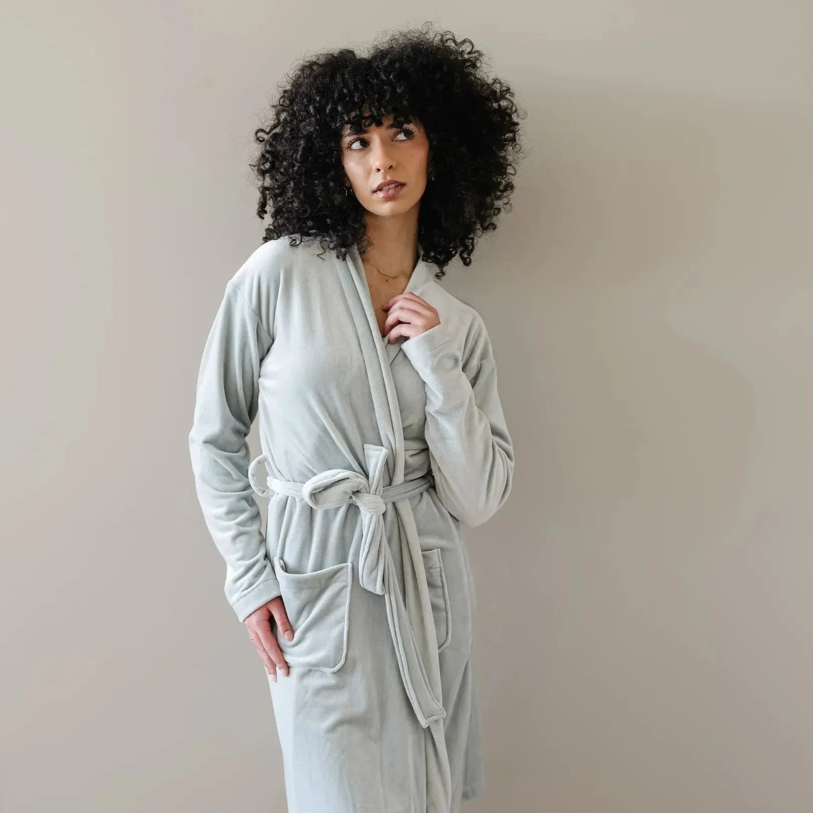 Woman in cozy light gray plush robe with belt and pockets, perfect for farmhouse or cottage style bath essentials