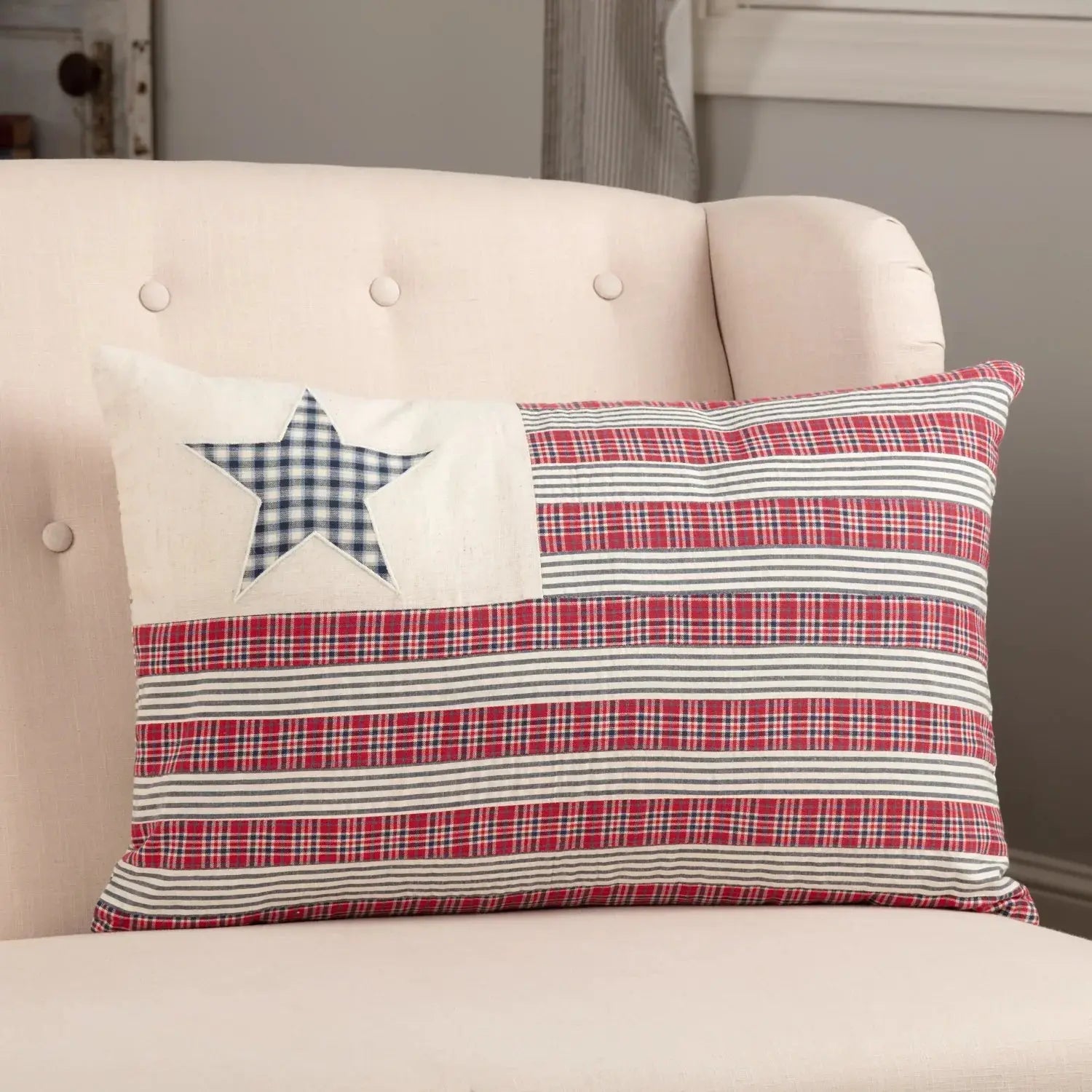 Red, white, and blue plaid pillow with star design on cozy farmhouse chair