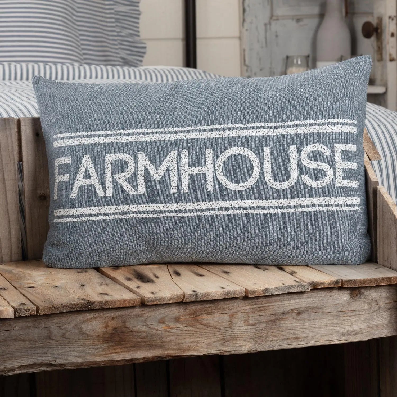 Gray farmhouse pillow with white text on rustic wood bench, cozy cottage decor