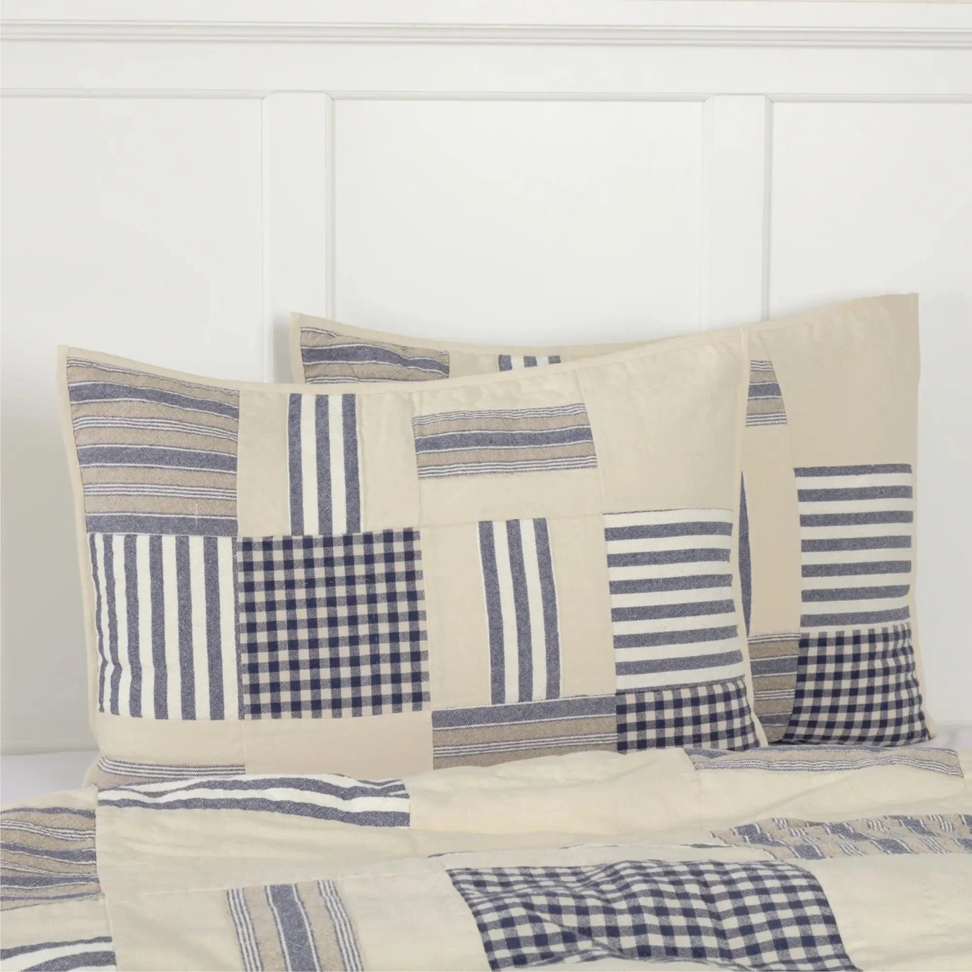 Farmhouse patchwork quilt set with blue and beige stripes and gingham patterns on cozy bedding