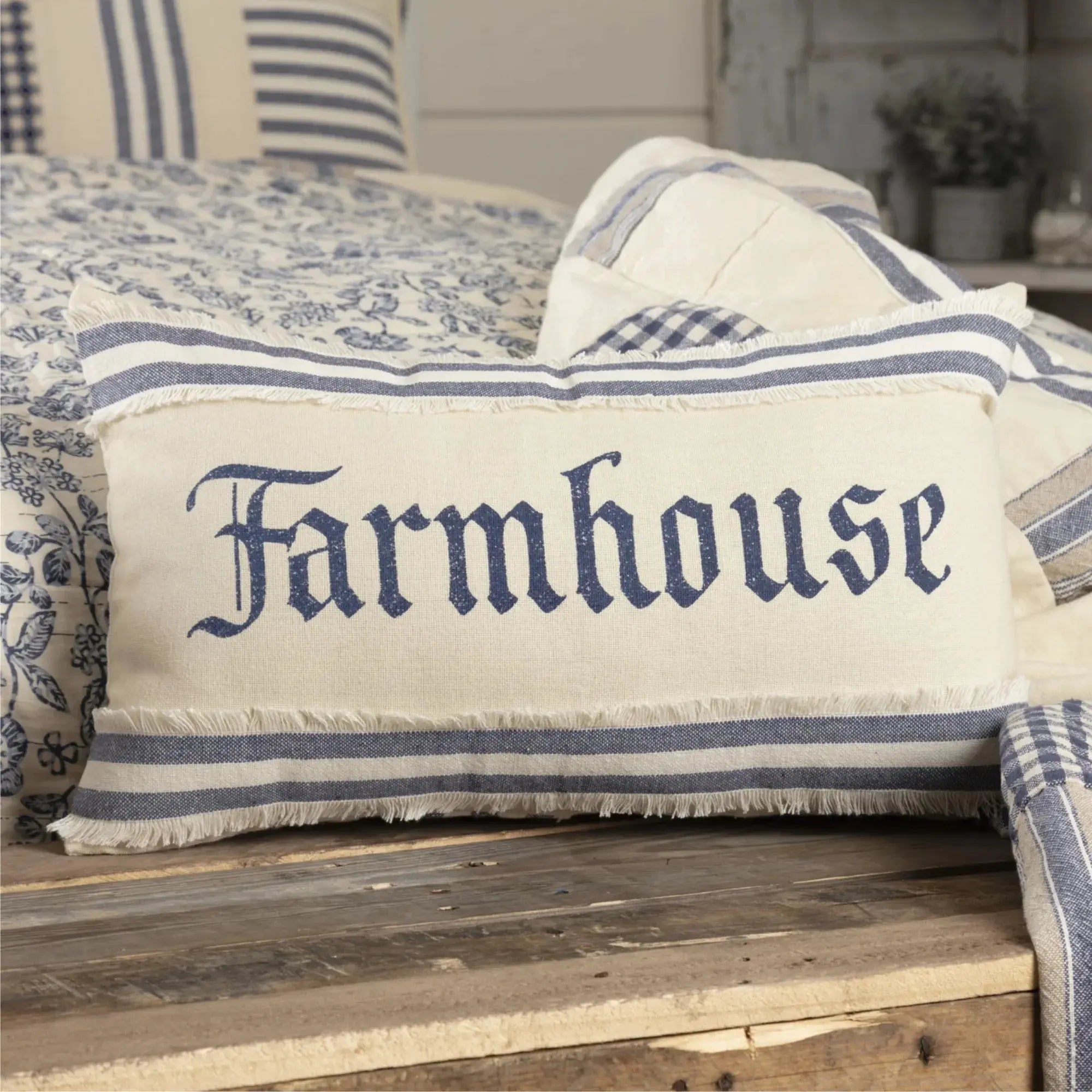 Farmhouse pillow with blue stripes and frayed edges on rustic wood, cozy cottage decor