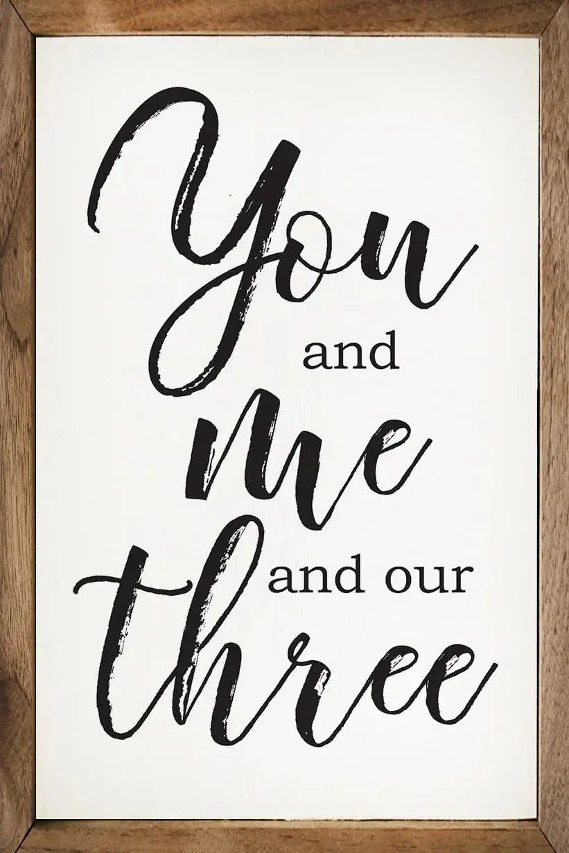 Framed farmhouse sign with 'You and me and our three' in black script, cozy cottage decor