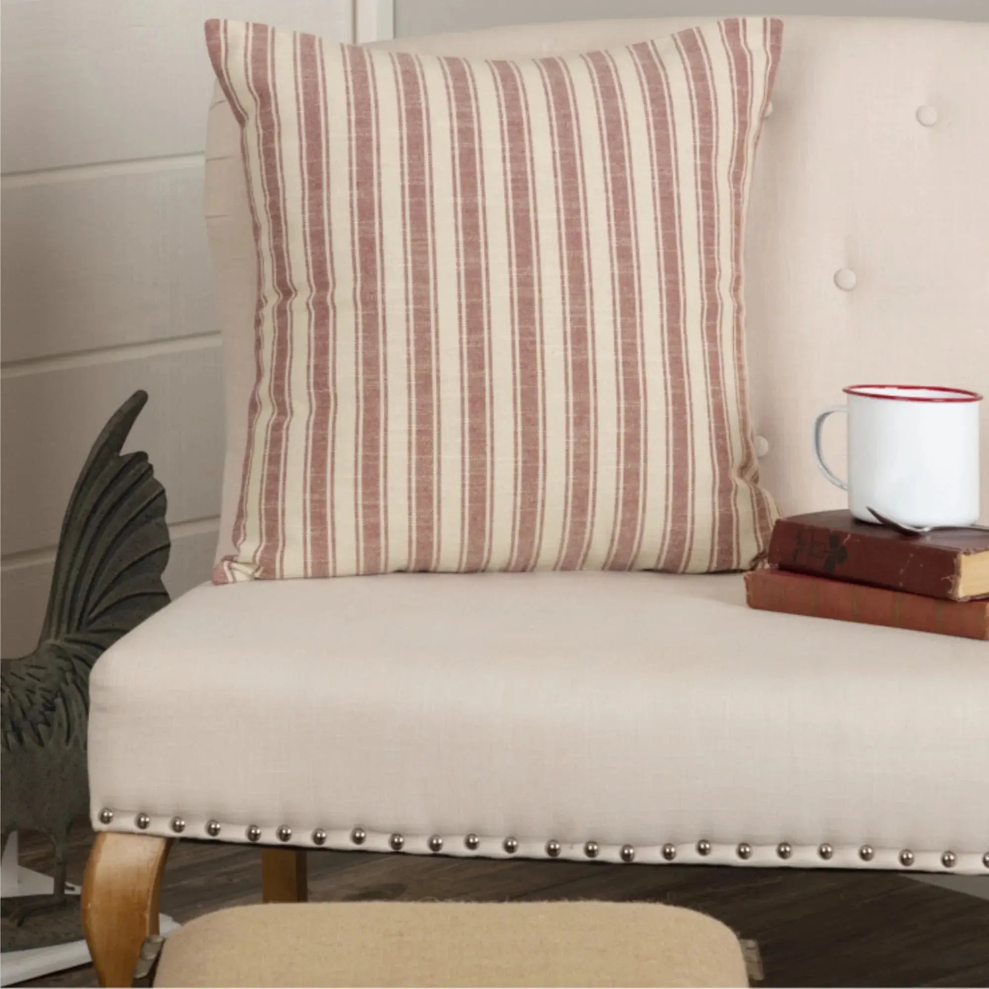 Striped farmhouse throw pillow on cozy chair with books and mug, rustic cottage decor