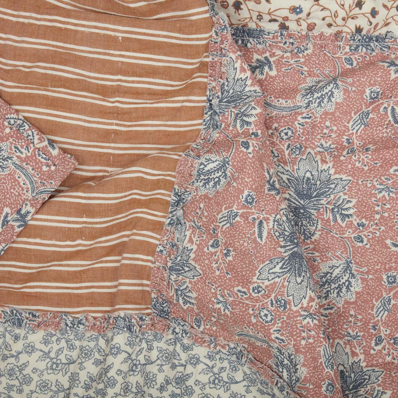 Cozy farmhouse quilt with striped and floral patterns in warm tones for cottage-style home decor