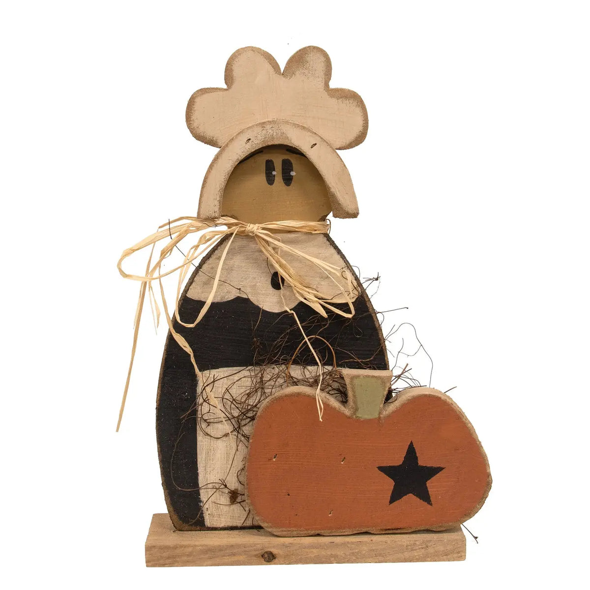 A rustic wooden decorative figure with a cowboy hat, black shirt, and straw details, standing next to a small orange pumpkin with a black star, on a white background.