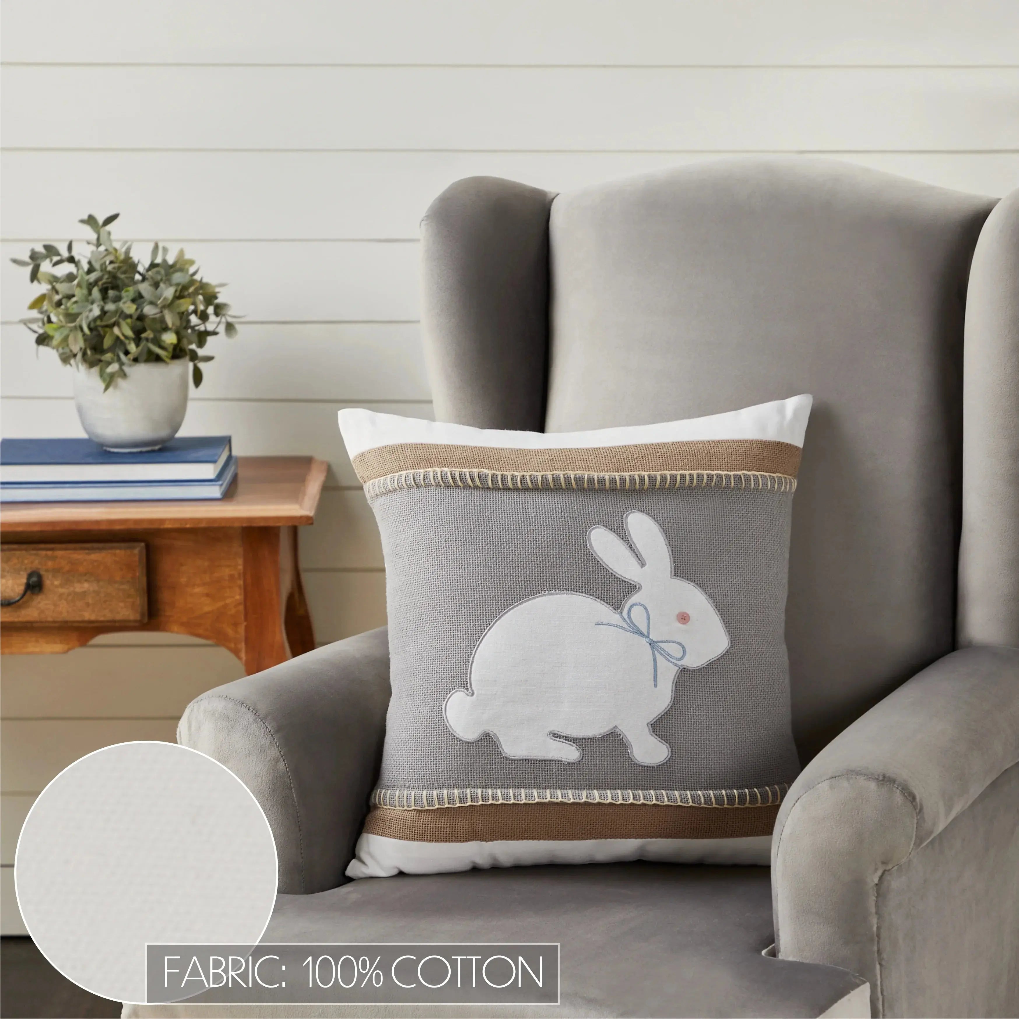 Gray bunny appliqué pillow with burlap trim, 100% cotton, cozy farmhouse decor on armchair