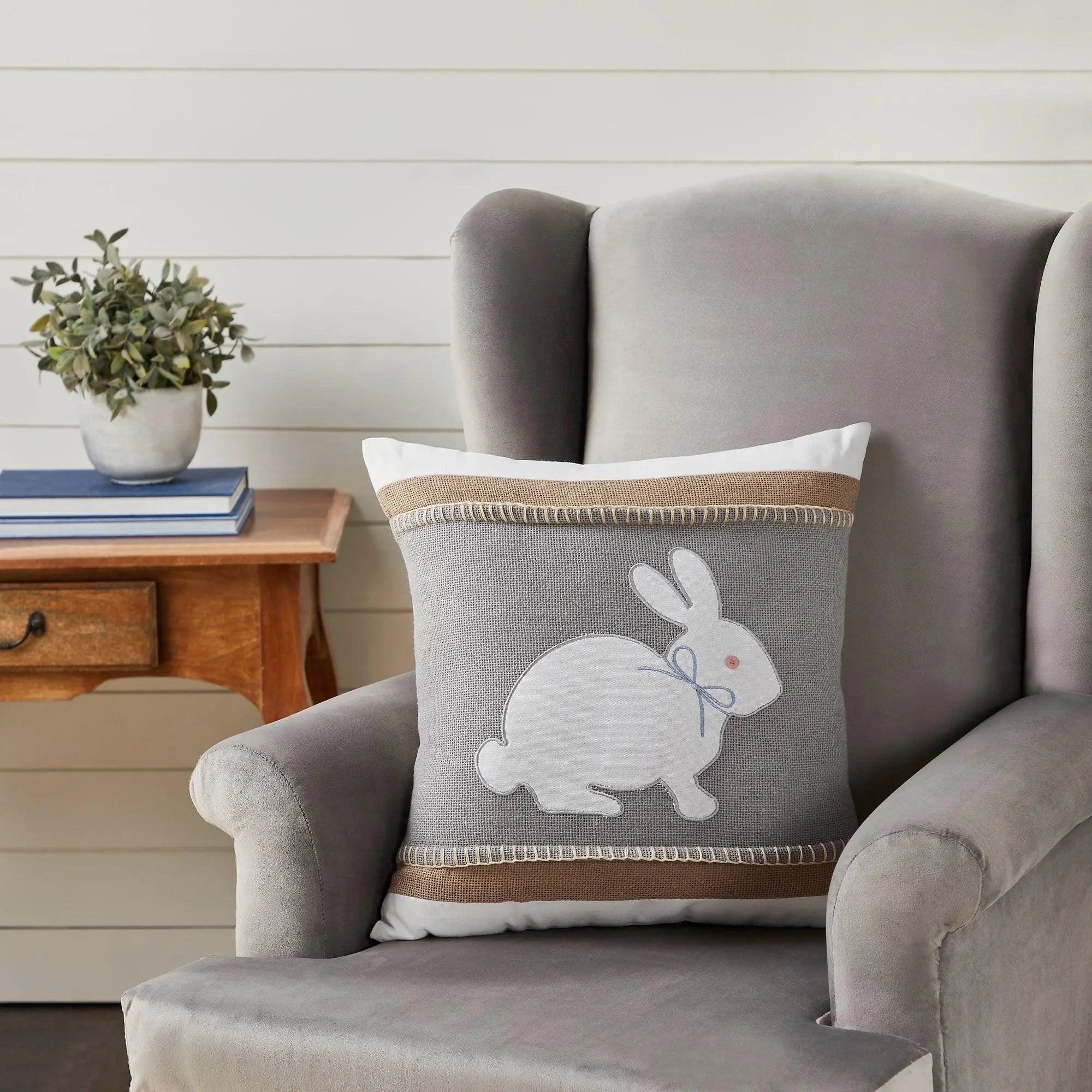 Gray bunny throw pillow with burlap trim on cozy armchair, farmhouse cottage decor