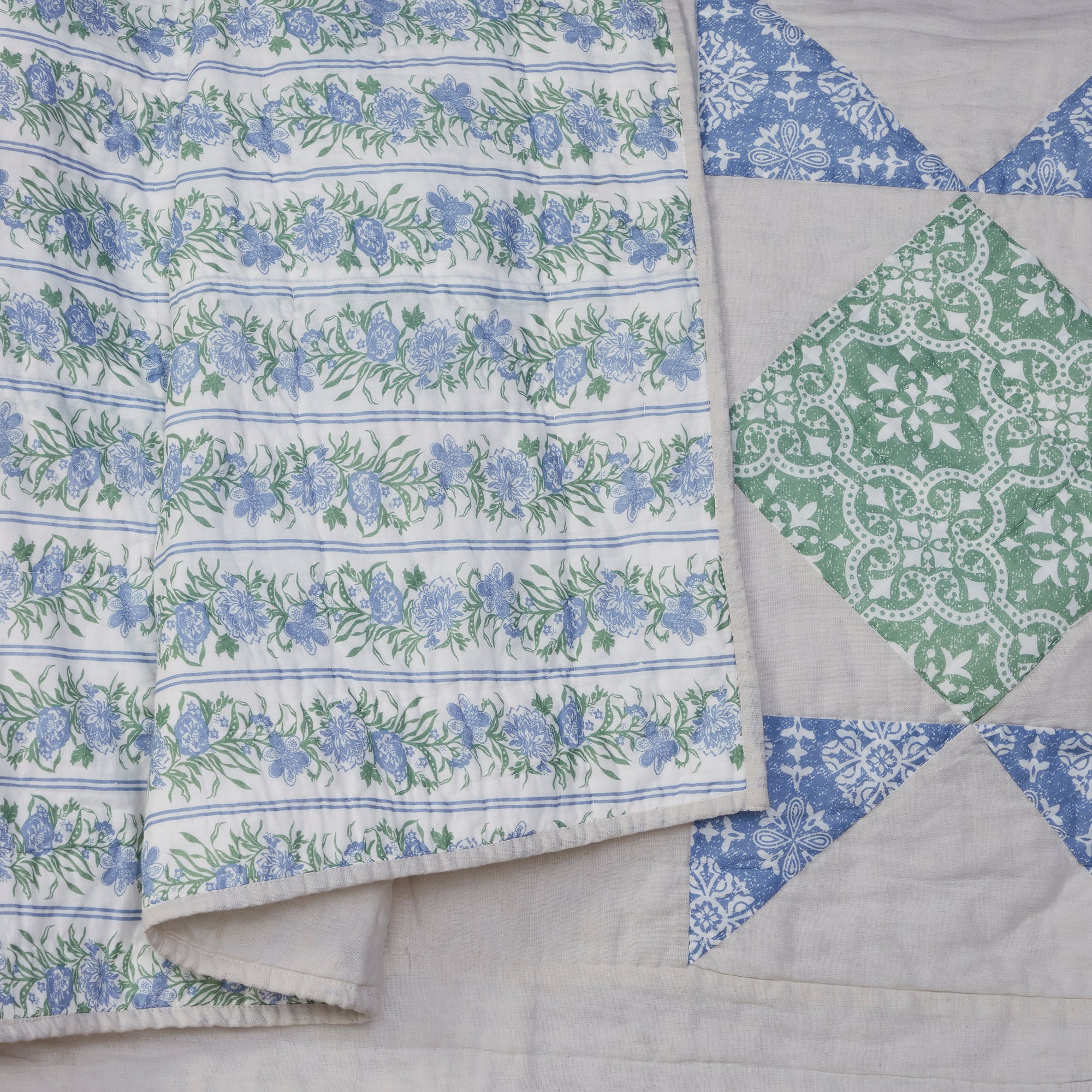 Quilt with floral and geometric patterns on a light background