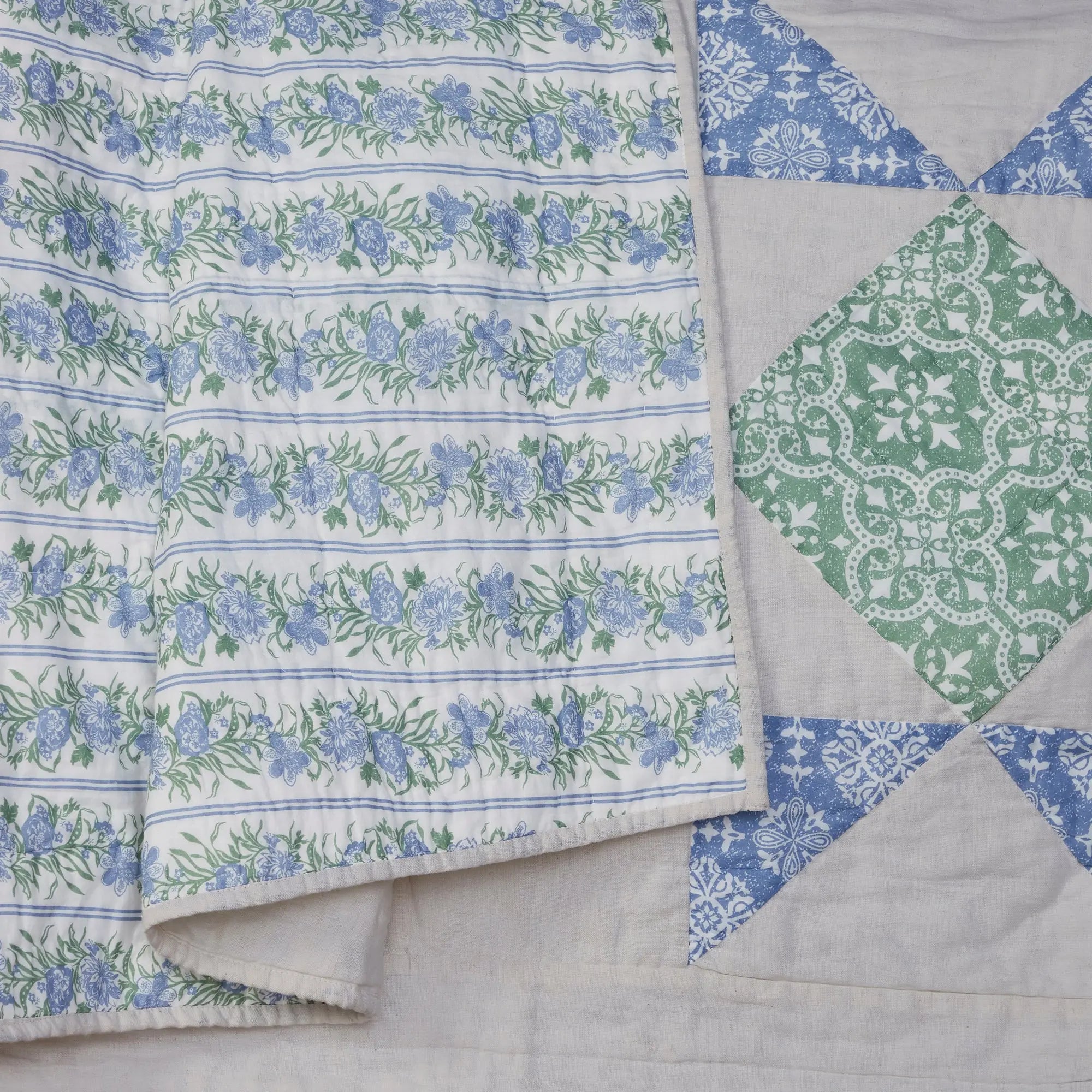 Quilt with floral and geometric patterns on a light background