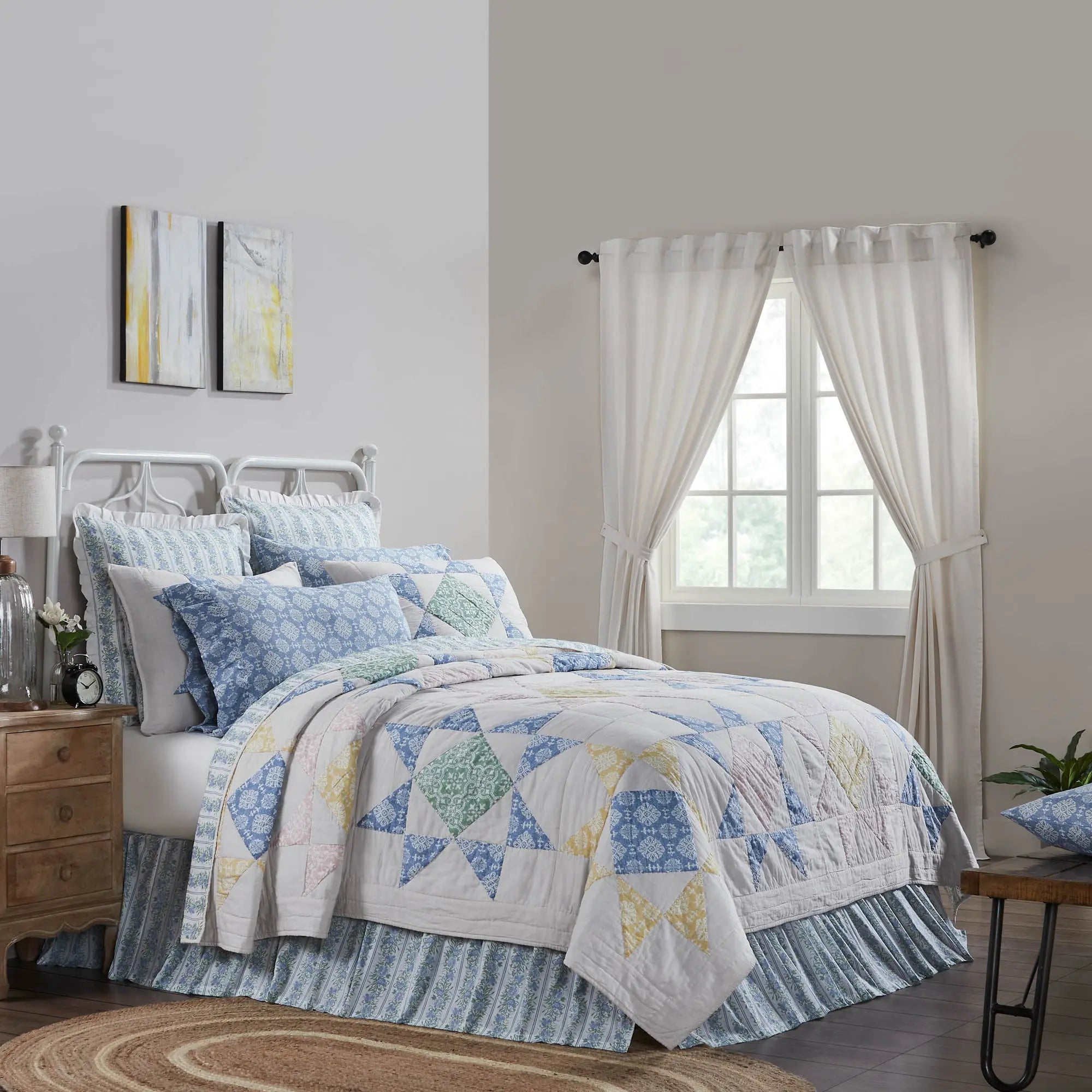Bedroom with a colorful quilt on a bed, wooden nightstands, and white curtains.