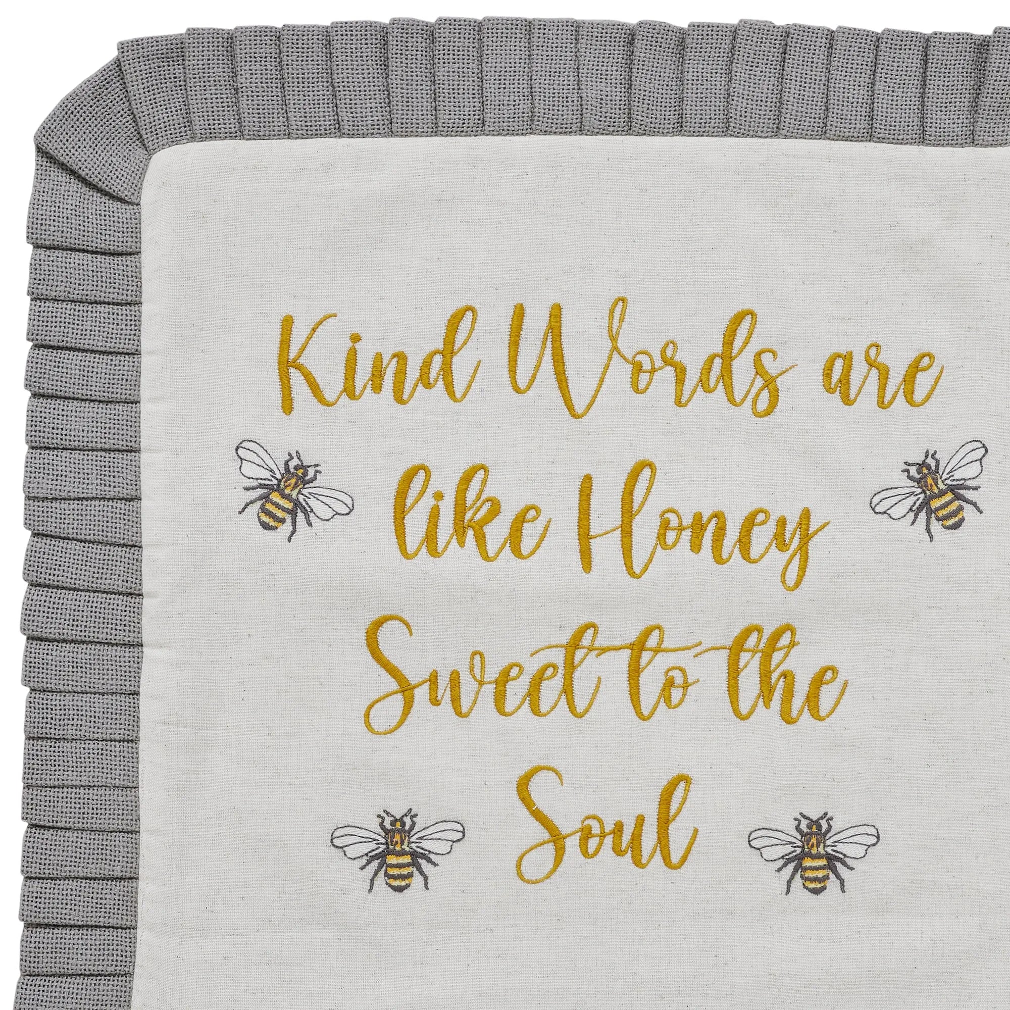 Blanket with gold text and bee illustrations on a gray border