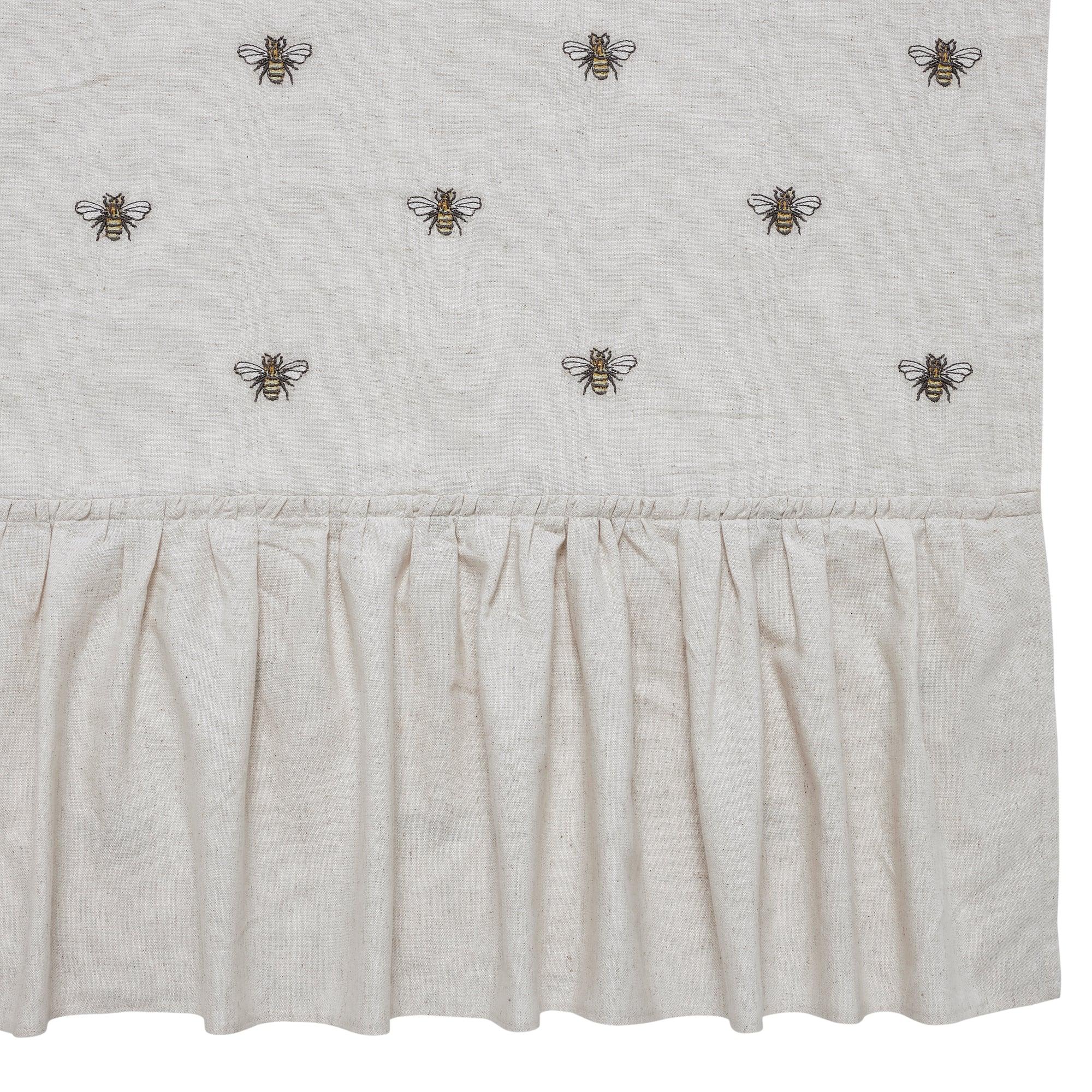 Beige curtain with embroidered bees on a white background