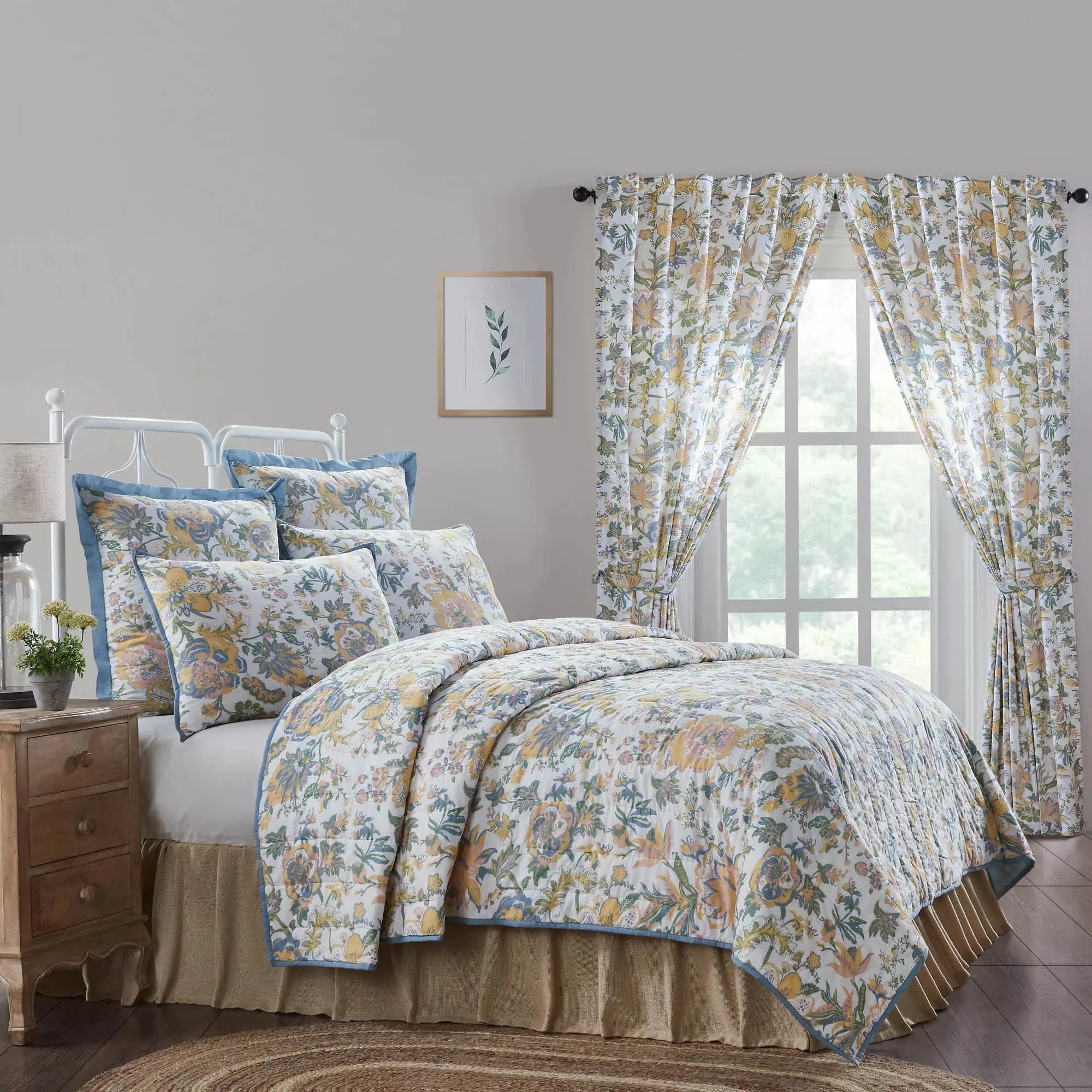 Floral quilt set with matching curtains in cozy farmhouse bedroom, featuring yellow and blue blooms on white