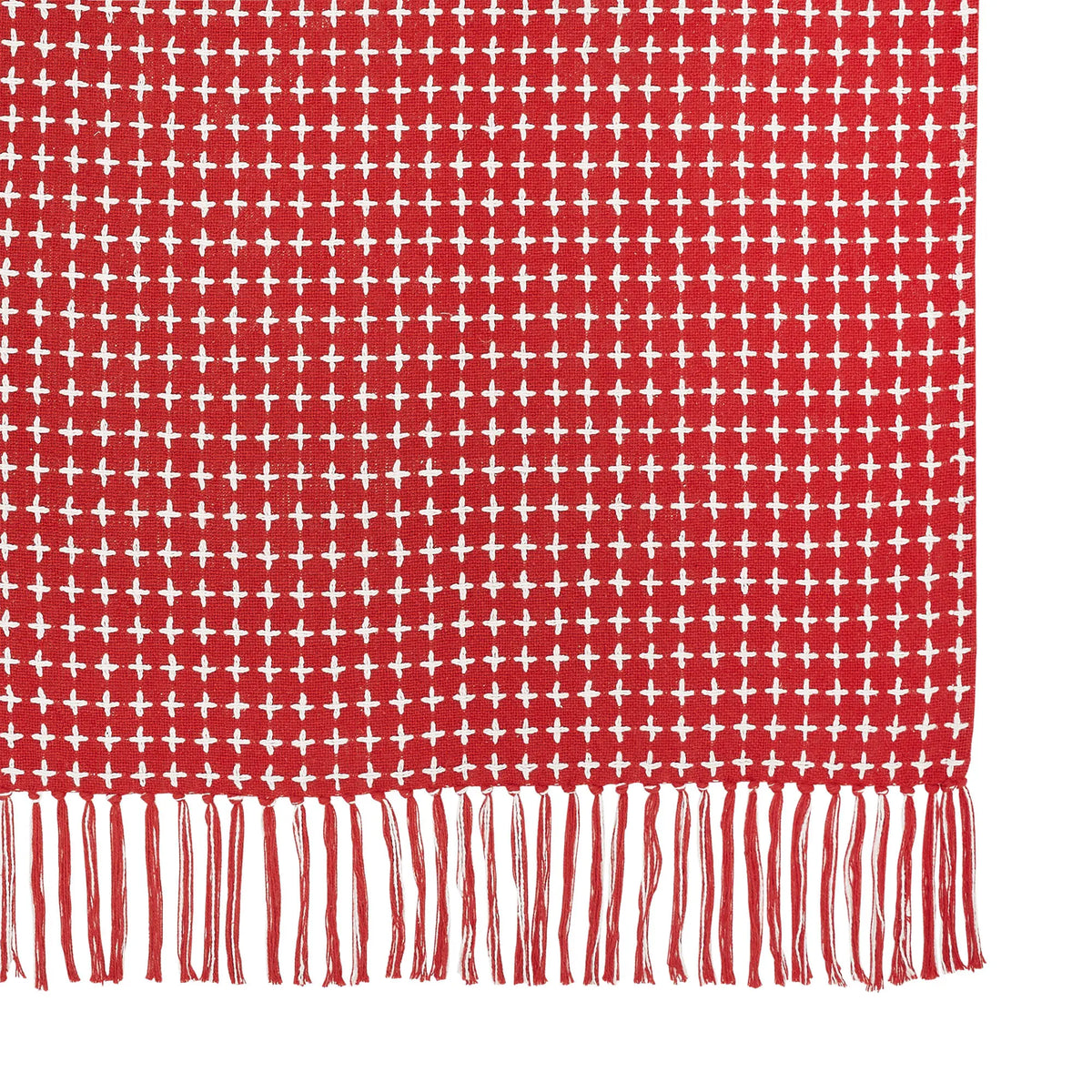 Red and white patterned fabric with fringes on a white background
