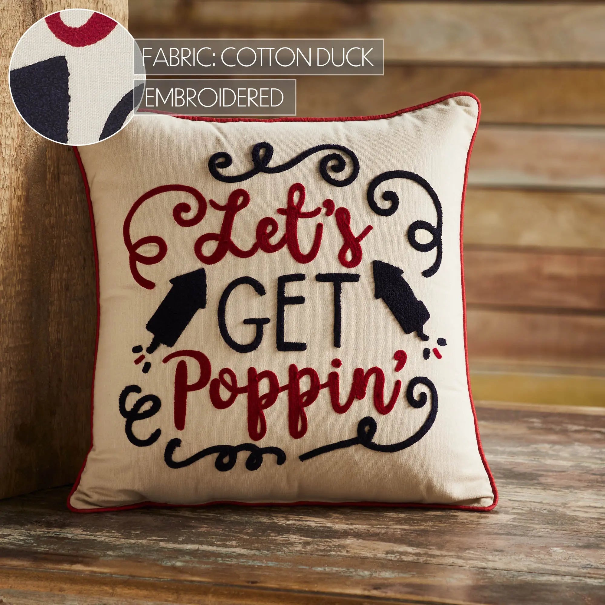 Decorative pillow with 'Let's Get Poppin'' text on a wooden surface
