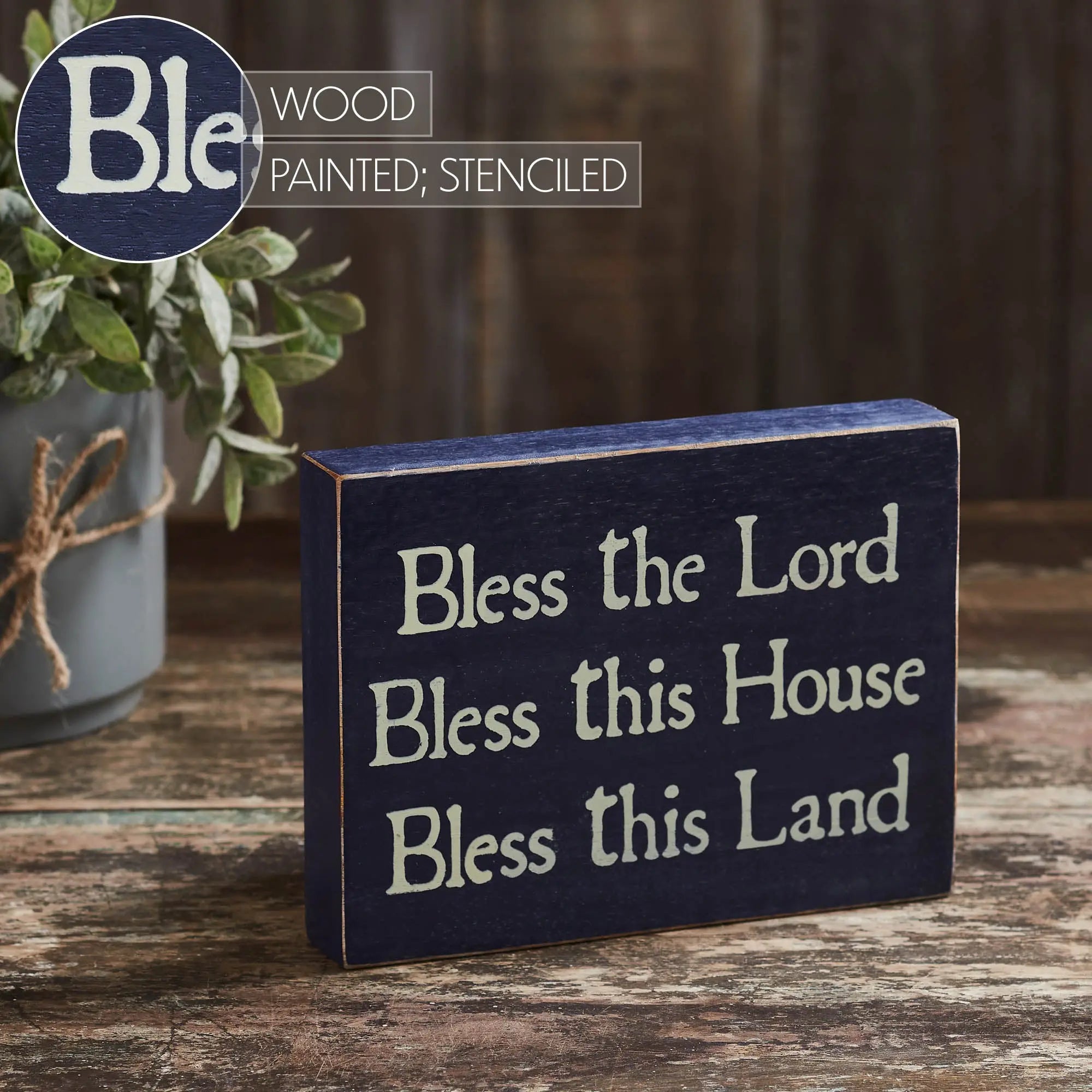 Wooden sign with text 'Bless the Lord Bless this House Bless this Land' on a wooden surface, with 'Ble' brand logo in the corner.