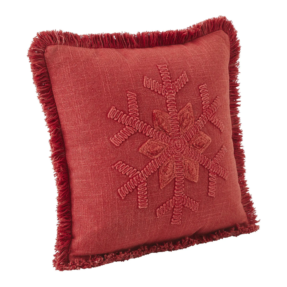 A square red throw pillow with a fringed border and a raised embroidered snowflake design in the center, shown on a plain white background.