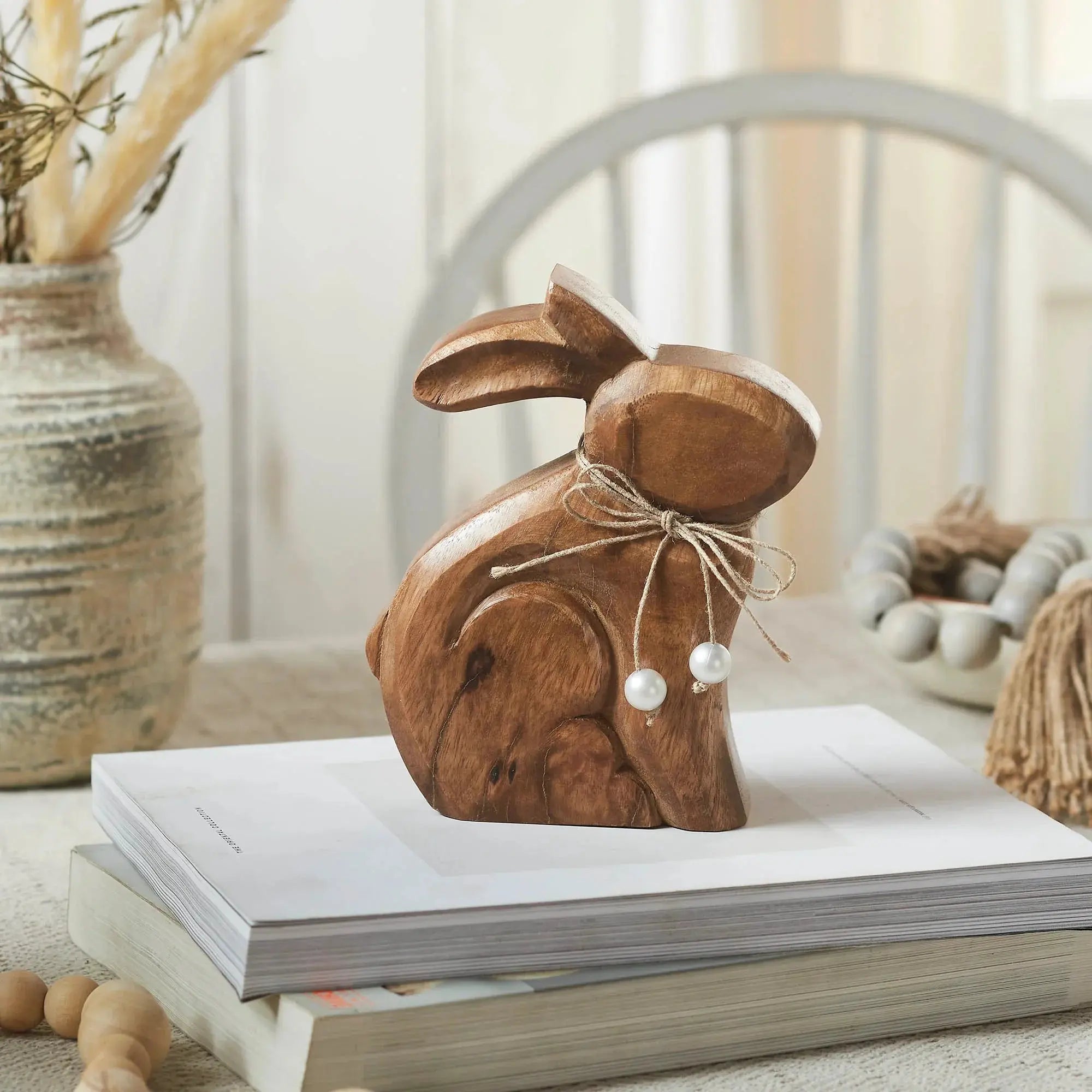 Wooden bunny decor with twine bow and pearls, styled with books and shower steamers for cozy farmhouse home accents