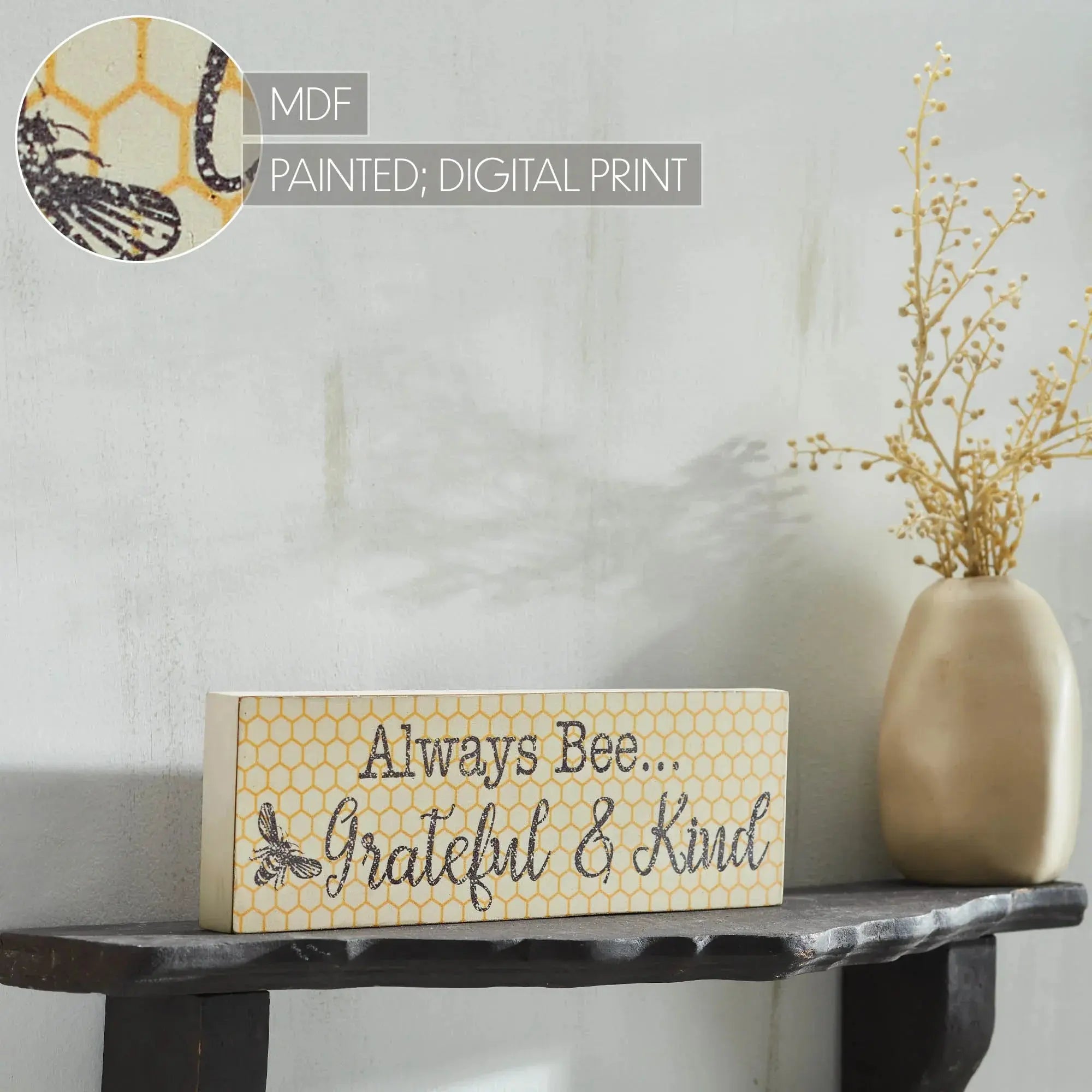 Farmhouse bee sign with honeycomb pattern, 'Always Bee Grateful & Kind' on shelf beside vase