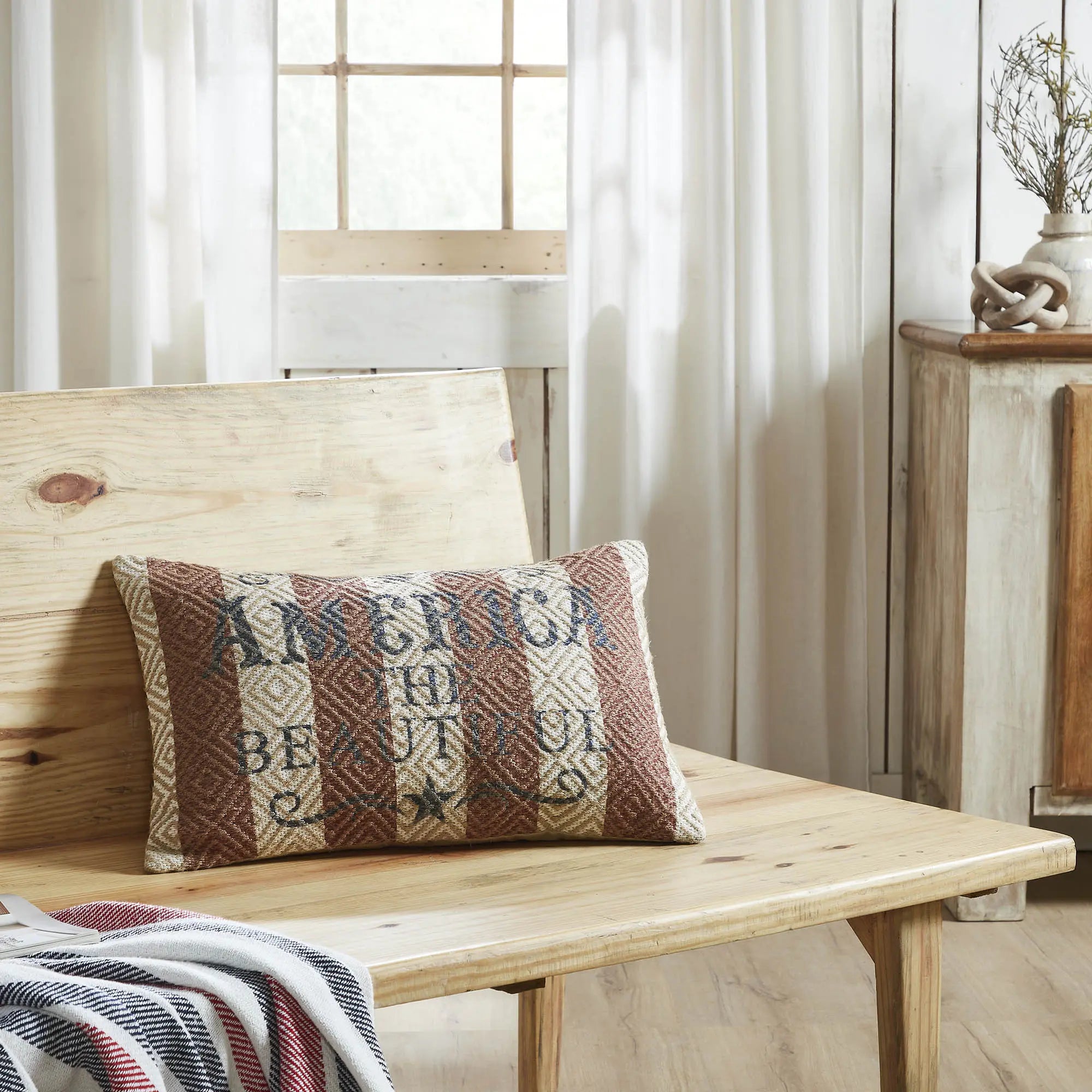 Decorative pillow with text on a wooden bench in a home setting