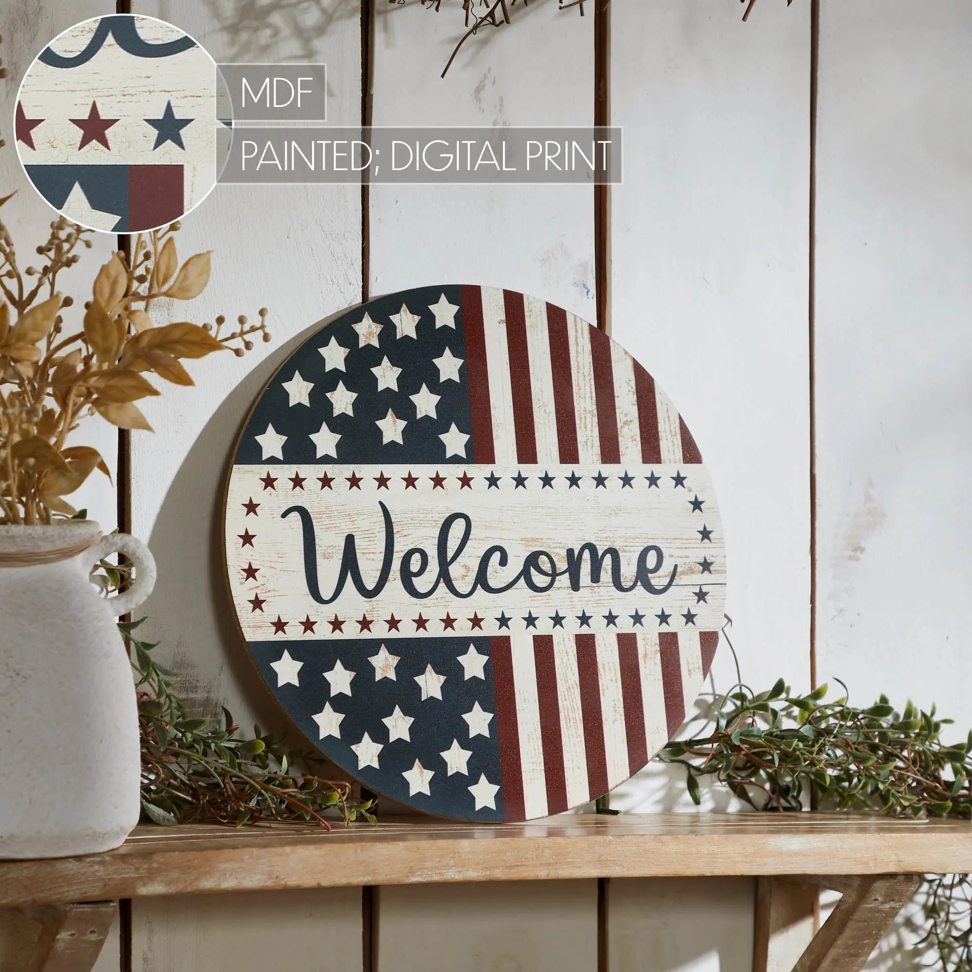 Decorative round sign with American flag design and 'Welcome' text on a wooden surface.