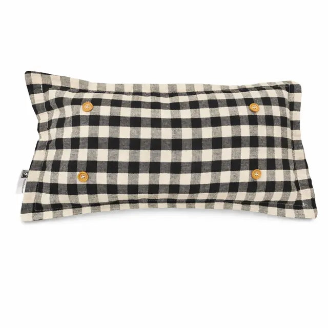 A rectangular lumbar pillow with a black and cream gingham check pattern, featuring four decorative wooden buttons on the front and a small fabric brand tag on the left side.