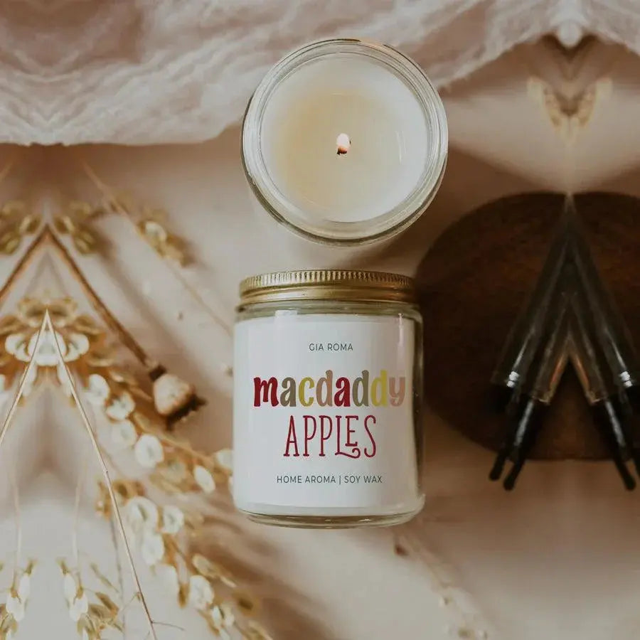 Candle in a glass jar with a decorative label on a textured surface