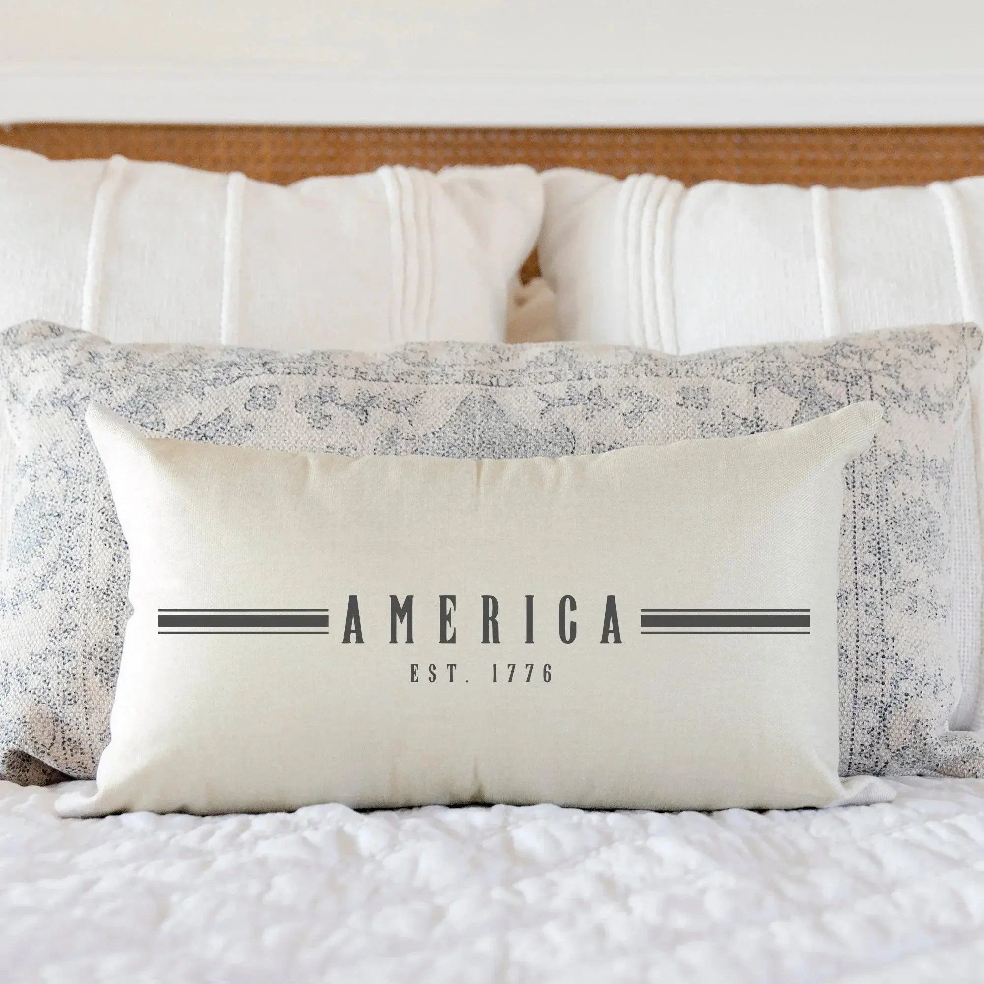 Cream farmhouse pillow with 'America Est. 1776' text, cozy cottage bedroom decor