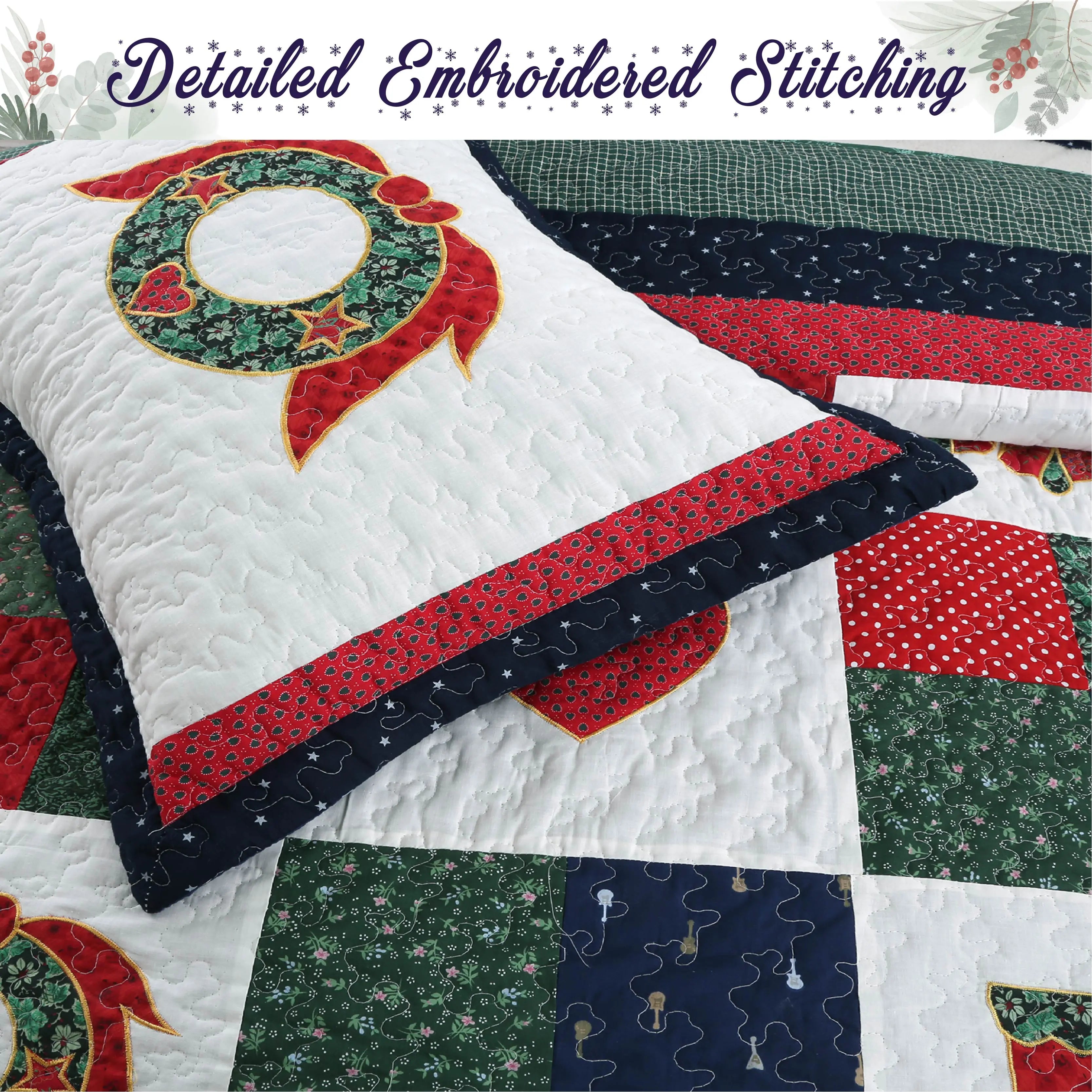 A quilted patchwork blanket and matching pillow featuring a Christmas wreath design, with a banner at the top reading 'Detailed Embroidered Stitching'. The quilt has a white base with red, green, and navy patterned sections.