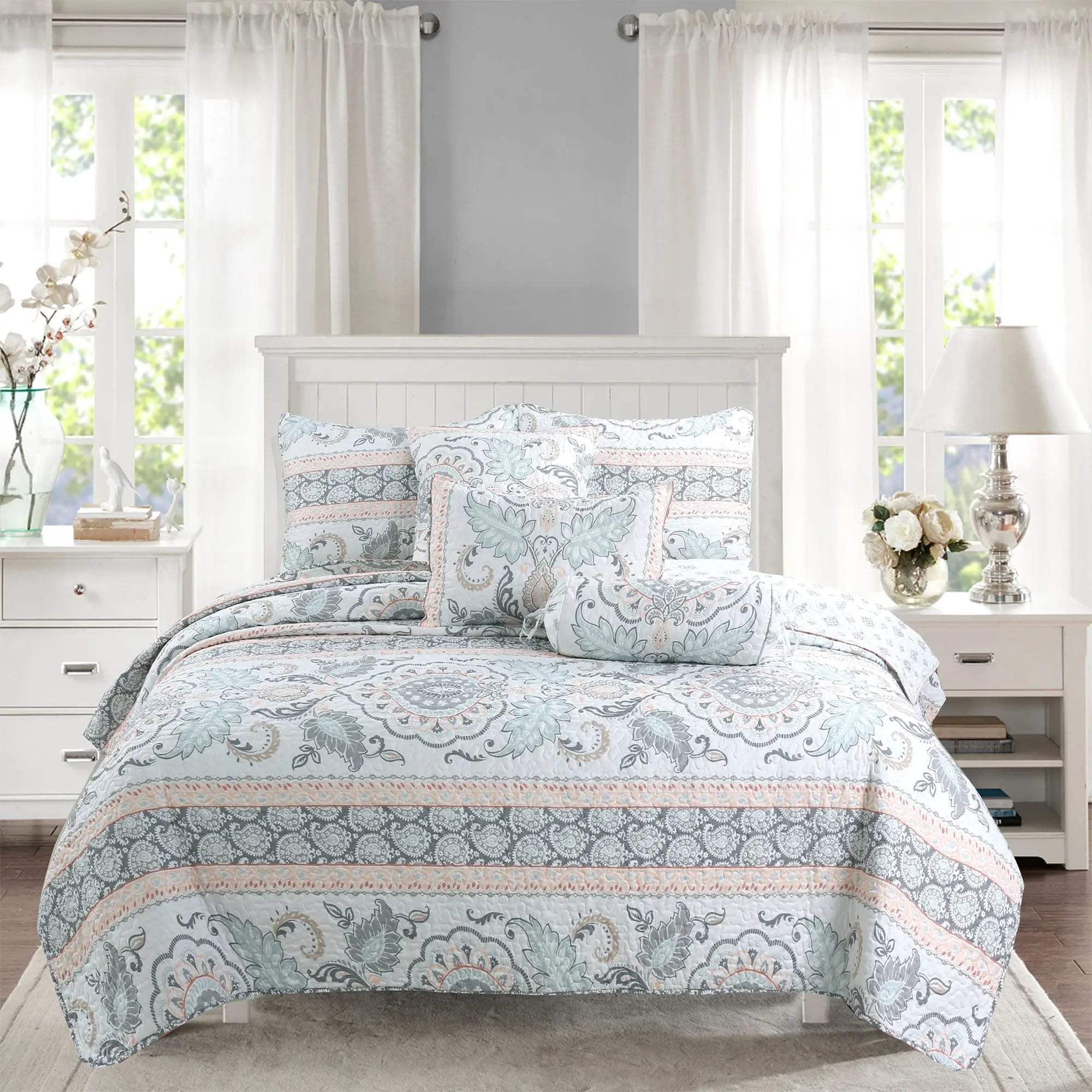Peach paisley floral reversible quilt bedding set with aqua blue and grey accents on a farmhouse style bed.