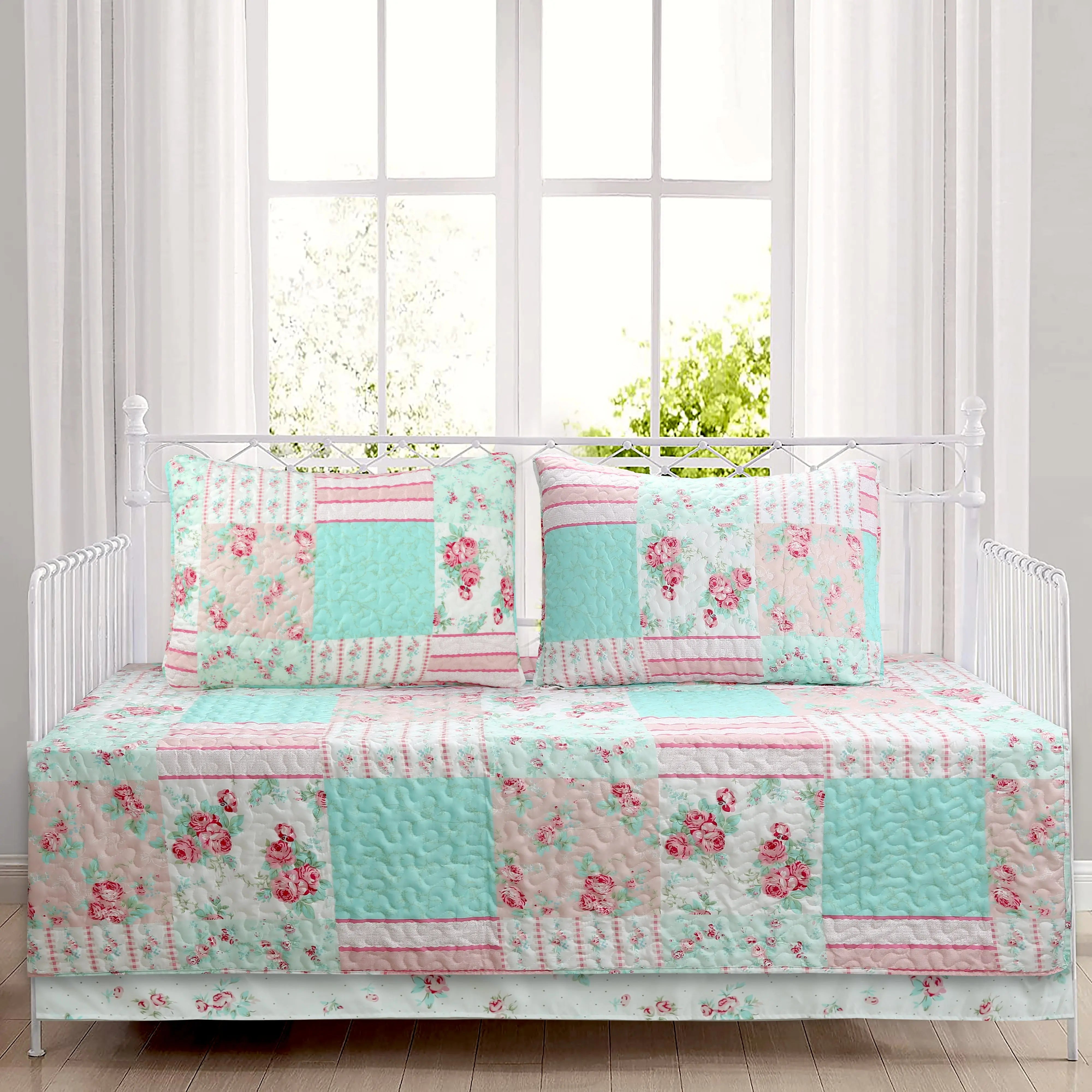 Tiffany Pink Blossom floral patchwork reversible daybed bedding set with pink floral quilt, matching shams, bed skirt, and decorative throw pillows in a cozy cottage bedroom.