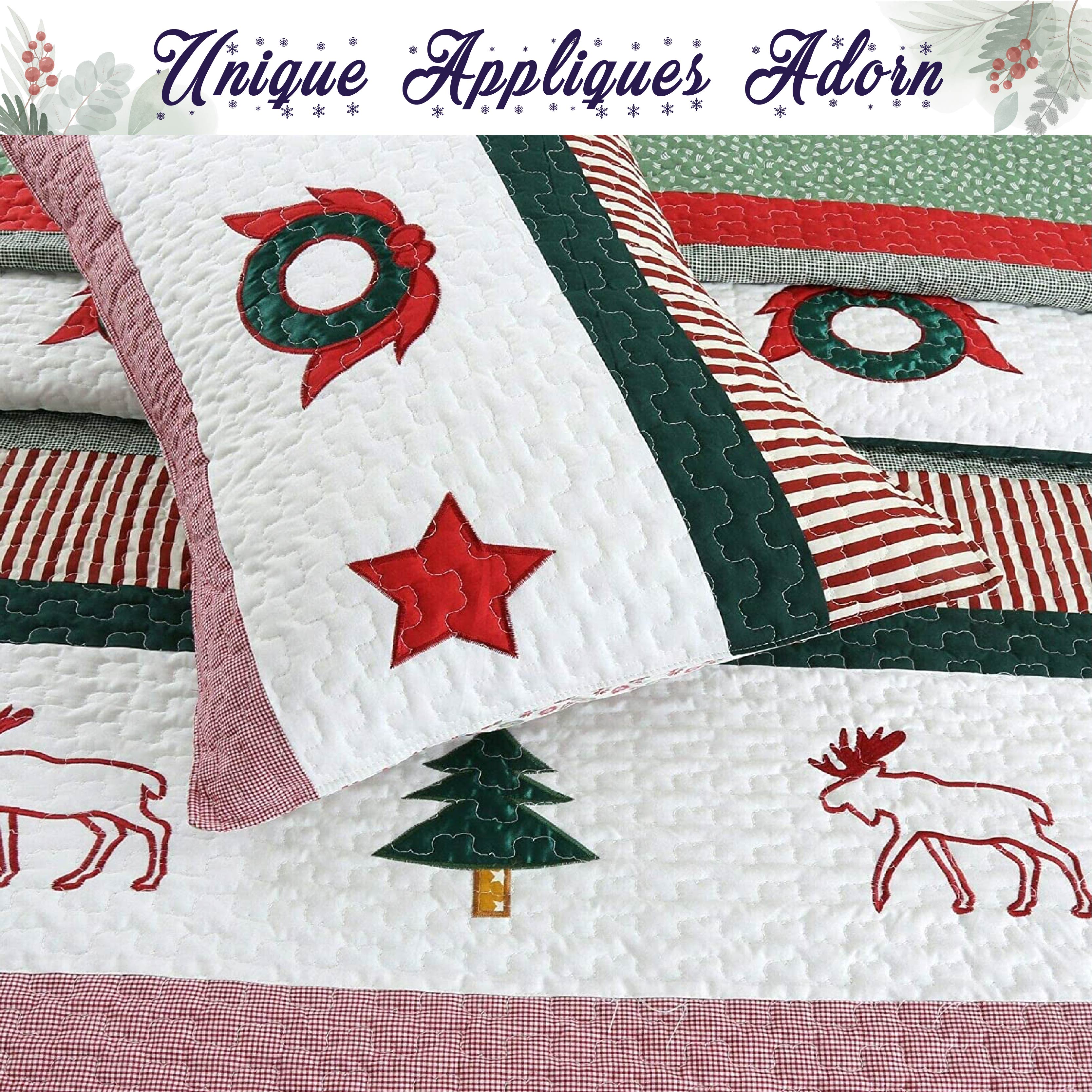 A quilted Christmas-themed bedding set featuring a white quilt with red and green appliques, including a wreath, star, tree, moose, and striped bands, with a matching pillow shown in front.