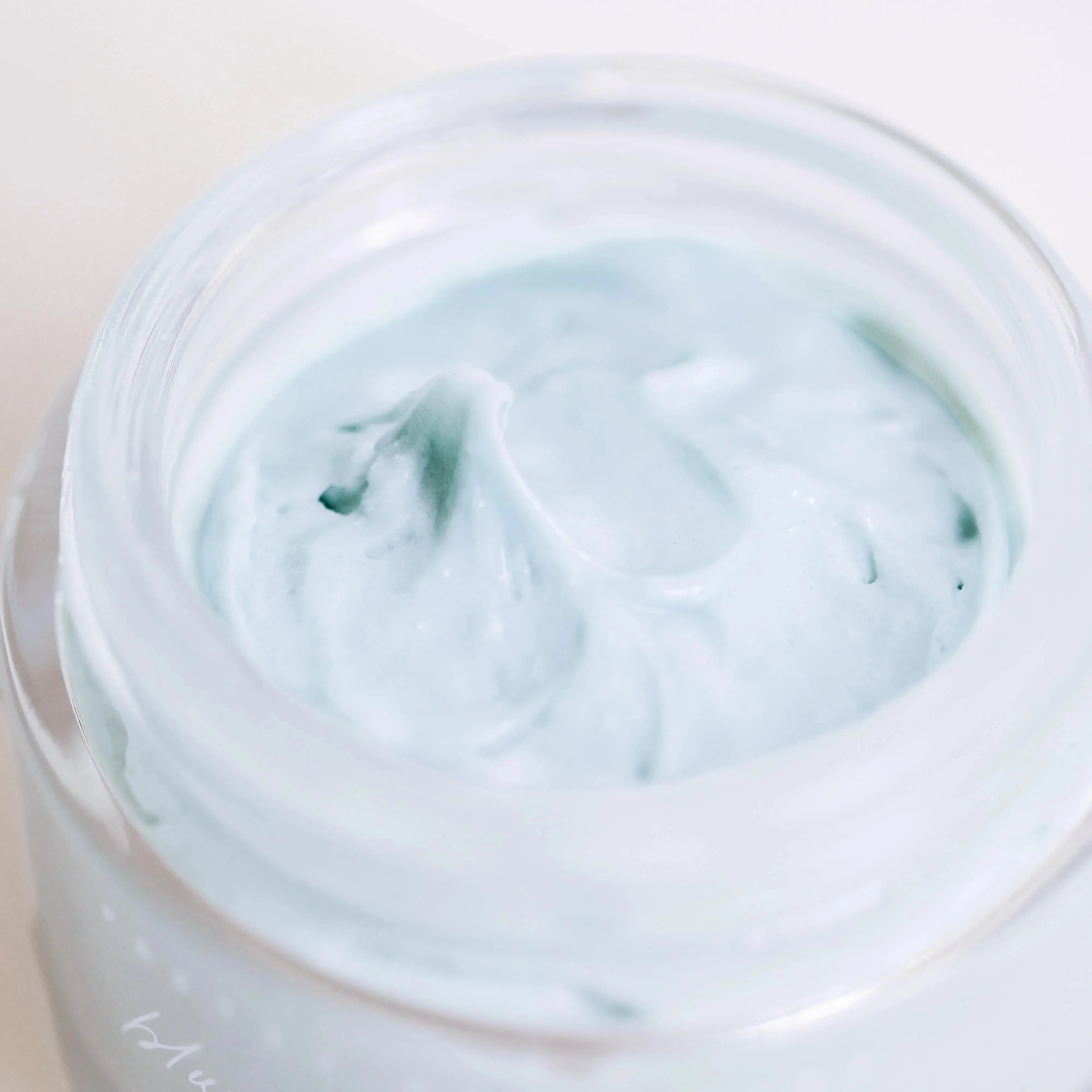 Light blue whipped bath cream in a clear jar, perfect for cozy farmhouse bathroom essentials.