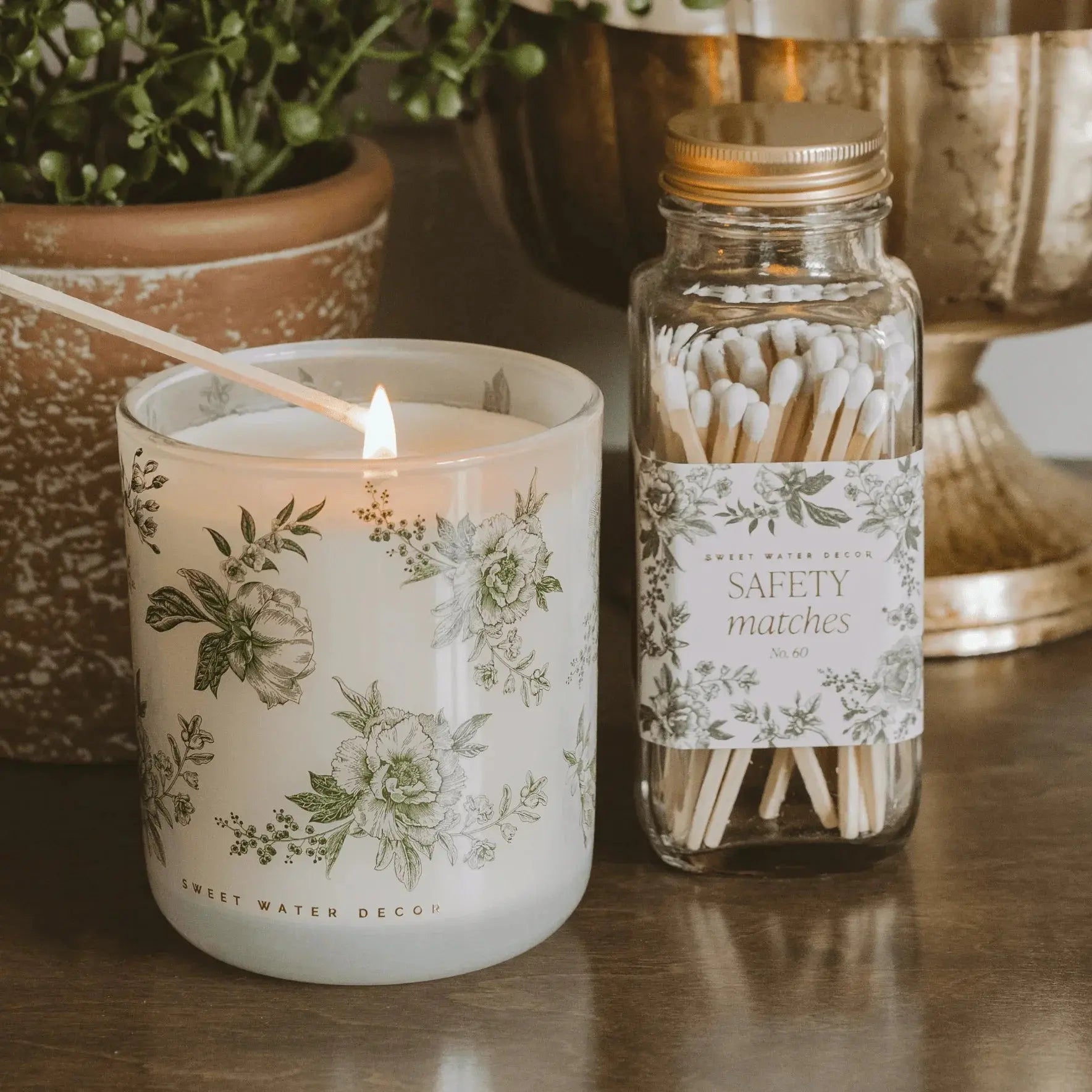 Floral candle and safety matches in farmhouse decor style, cozy home ambiance with greenery