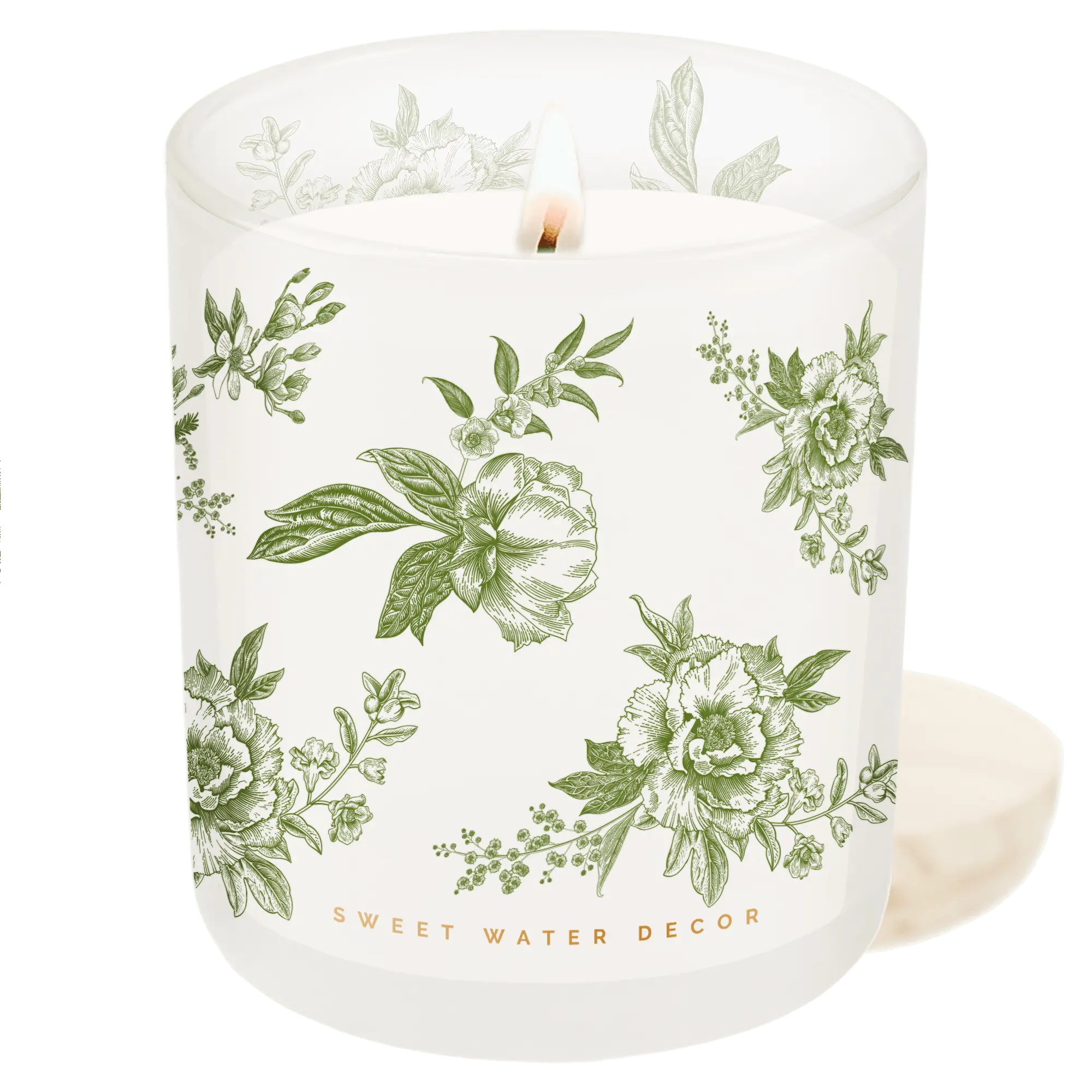 Lit floral candle in white glass jar with green botanical print, cozy farmhouse decor